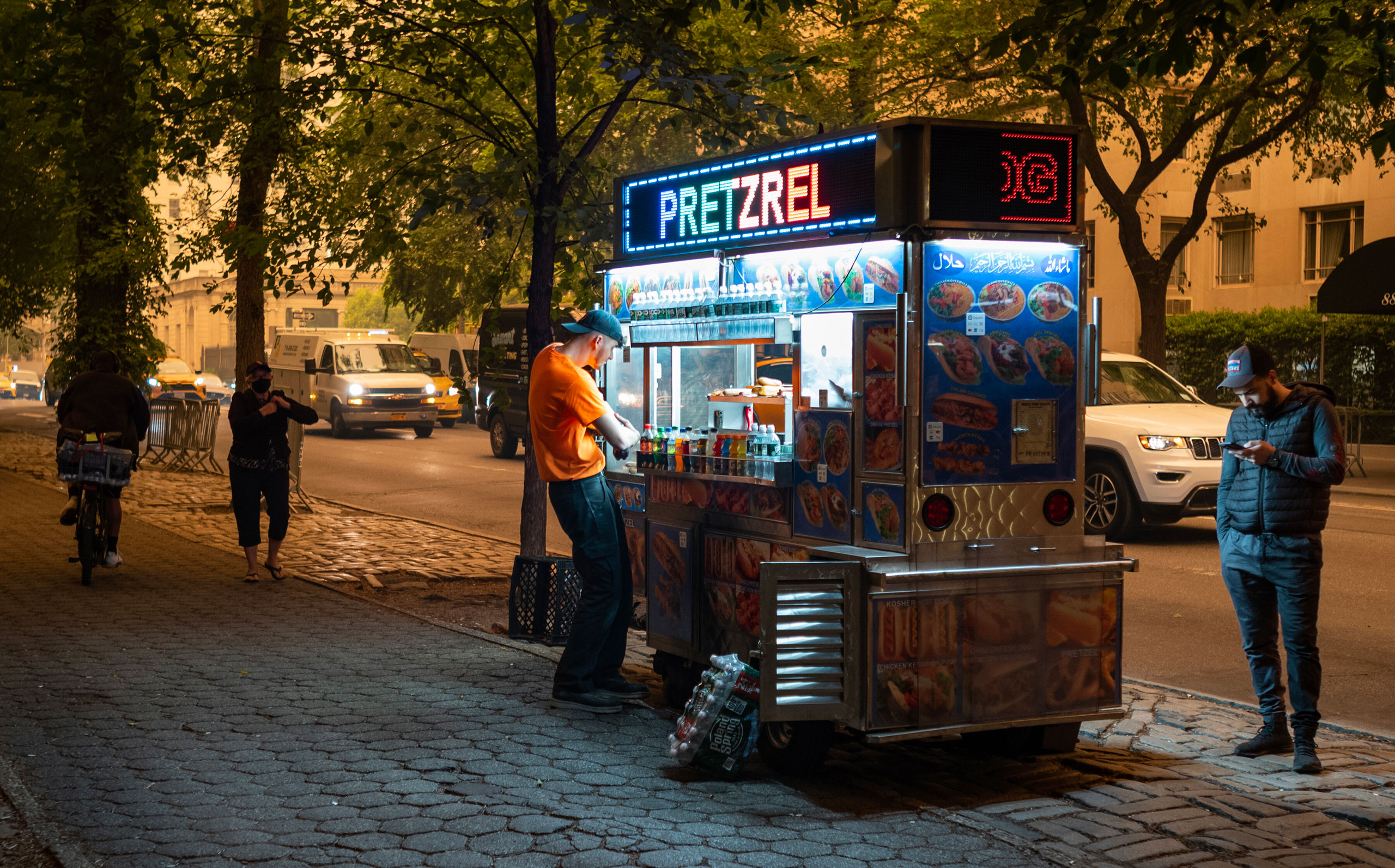 Light from a food vendor’s cart lights the sidewalk as smoke from wild fires in Northeast Canada is observed near Central Park in New York City, on June 7, 2023. (Craig Ruttle—Redux)