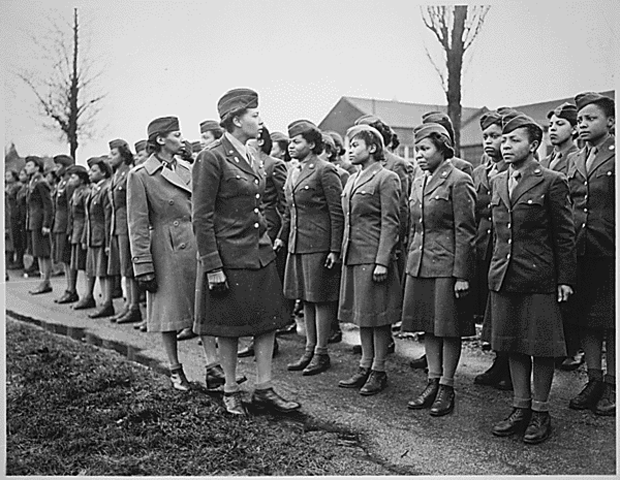 Charity Adams in uniform walks along a line of female soldiers inspecting their uniforms