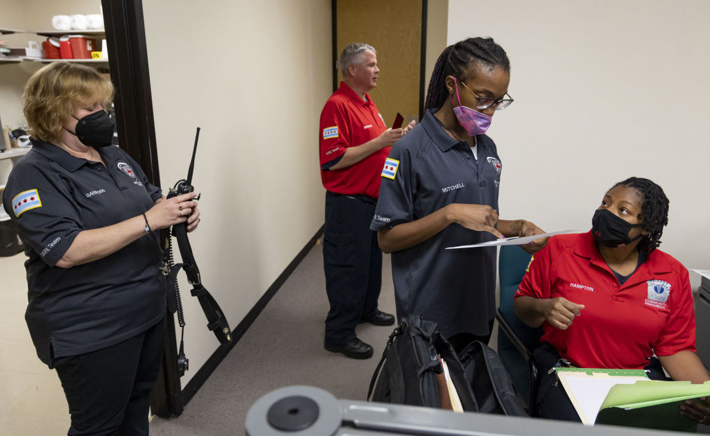 Mental health clinician Jennifer Garross, left, checks radios while Gabrielle Mitchell, also a mental health clinician, and community paramedic Tiana Hampton, talk on July 14, 2022, while the Chicago Crisis Assistance Response and Engagement (CARE) team starts the workday. (Brian Cassella—Chicago Tribune/Tribune News Service/ Getty Image)