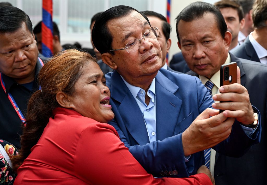 Cambodia Prime Minister Hun Sen takes a photo with a woman