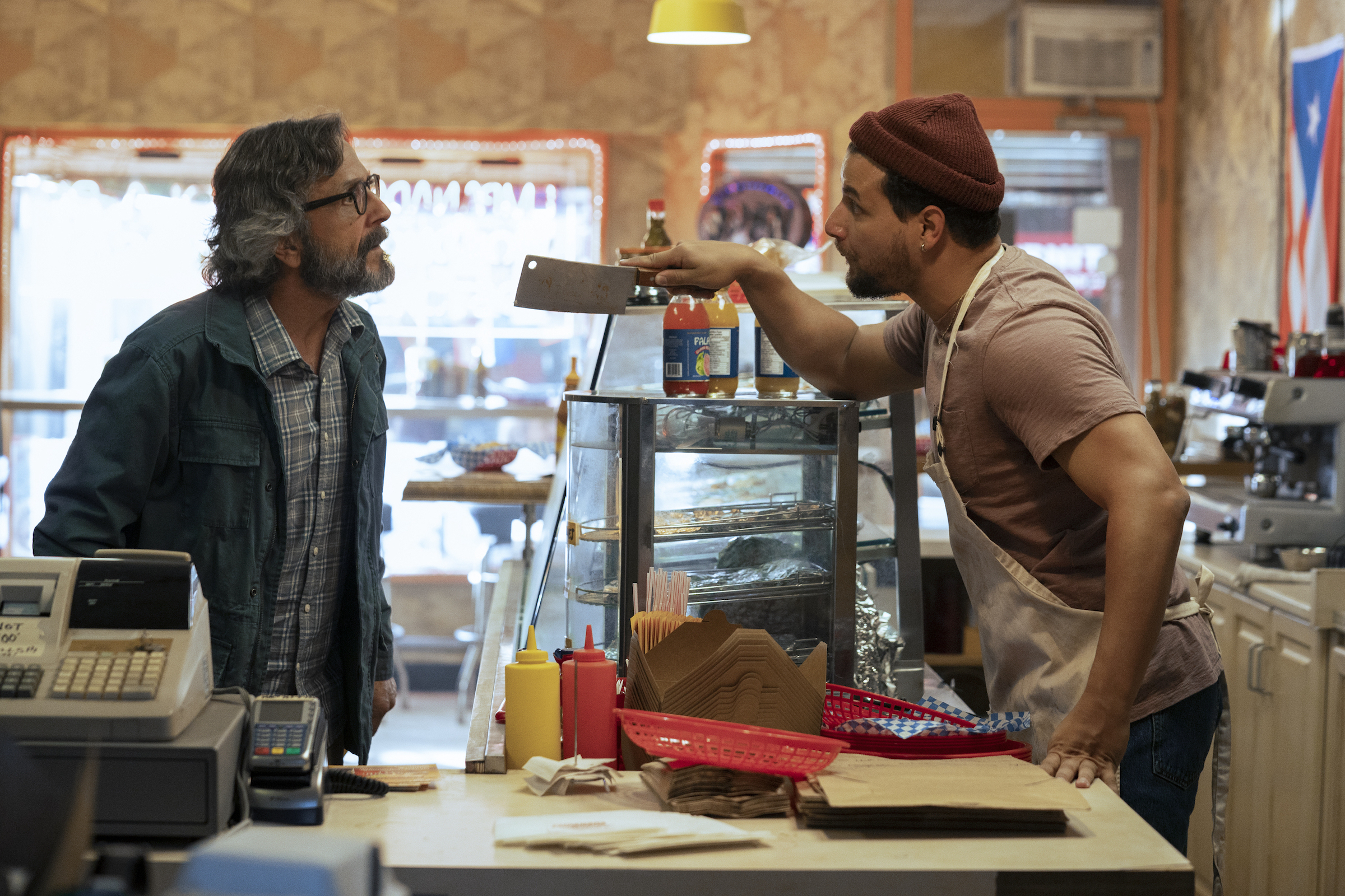 Luis (Alejandro Hernandez), the owner of Empanada Loca, argues with his landlord, Gideon Pearlman (Marc Maron), who has been threatening to evict him. (Jasper Savage—Prime Video)