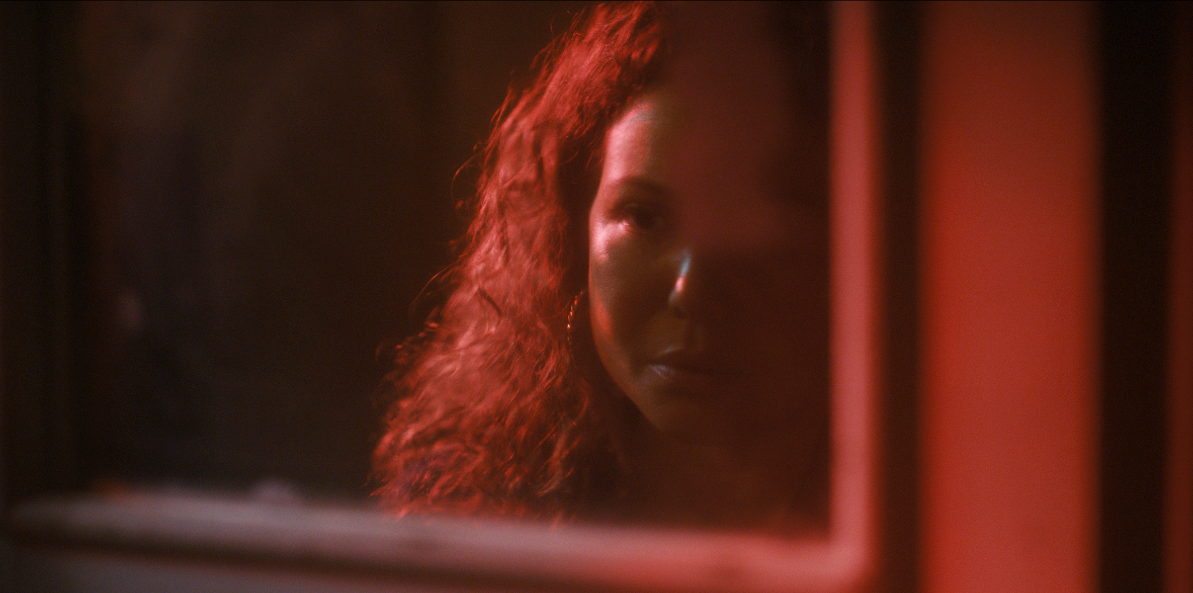 Dolores Roach (Justina Machado) contemplates her reflection in the mirror. (Courtesy of Prime Video)