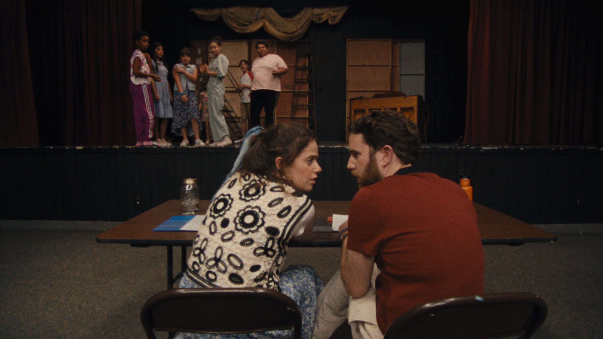 Theater instructors Rebecca-Diane (Molly Gordon) and Amos (Ben Platt) confer as a group of campers looks on. (Courtesy of Searchlight Pictures)