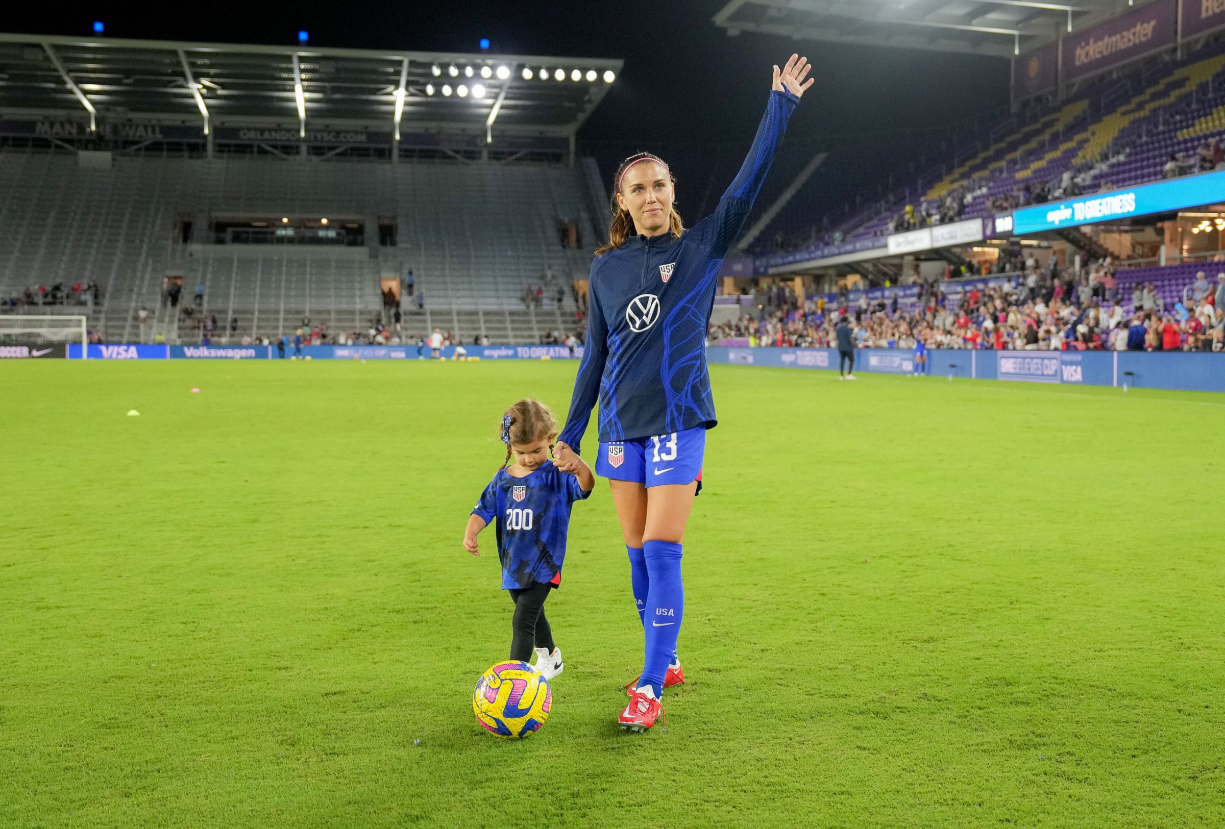 Alex Morgan and her daughter Charlie on the field