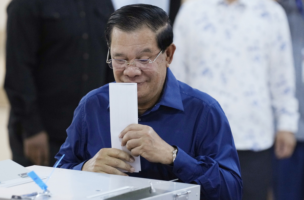 Cambodian Prime Minister Hun Sen of the Cambodian People's Party (CPP) kisses a ballot before voting at a polling station at Takhmua in Kandal province, southeast Phnom Penh, Cambodia, Sunday, July 23, 2023.