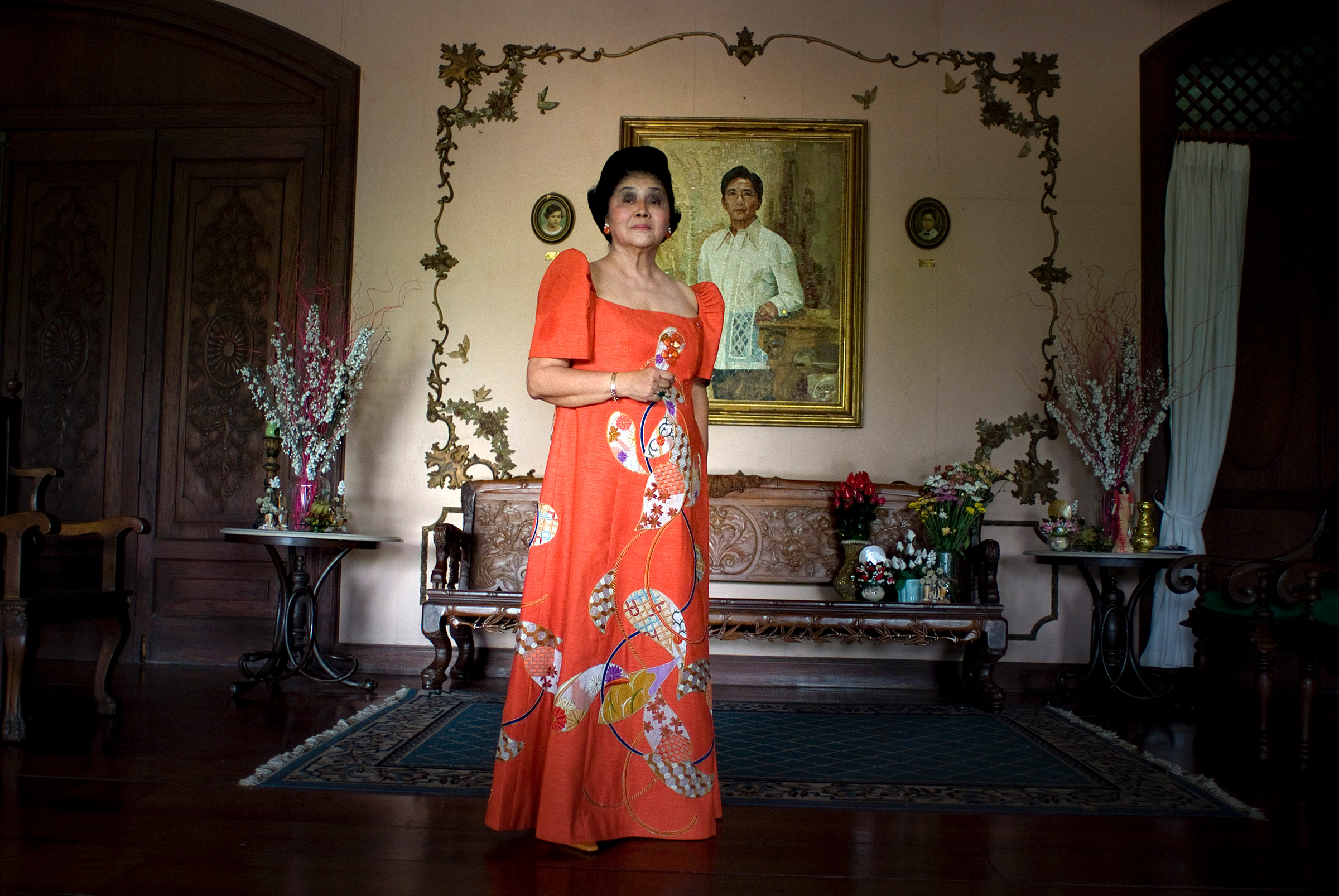 Imelda Marcos poses for a portrait in front of a painting of her late husband and former Philippines President Ferdinand Marcos, inside her home in Batac, Ilocos Norte, Philippines, in April 2010. (Jes Aznar—The New York Times/Redux)