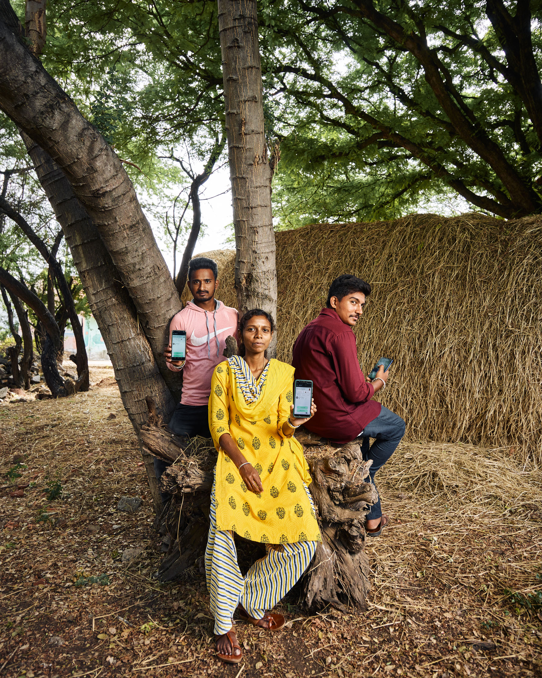 L to R: Santhosh (22), Chandrika (30) and Guruprasad (23) at a clearing spacewith haystacks in the background.