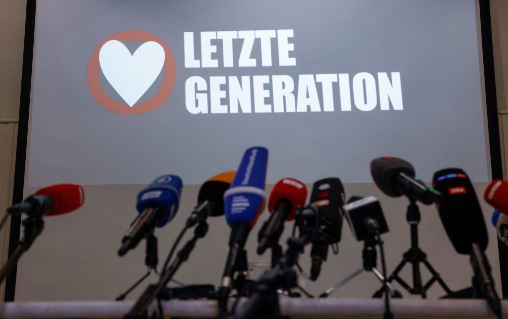 The logo of the "Letzte Generation" (Last Generation) group is seen behind a row of microphones ahead of a news conference in Berlin on May 24, 2023 following early morning raids by police on their activists. (ODD ANDERSEN/AFP—Getty Images)