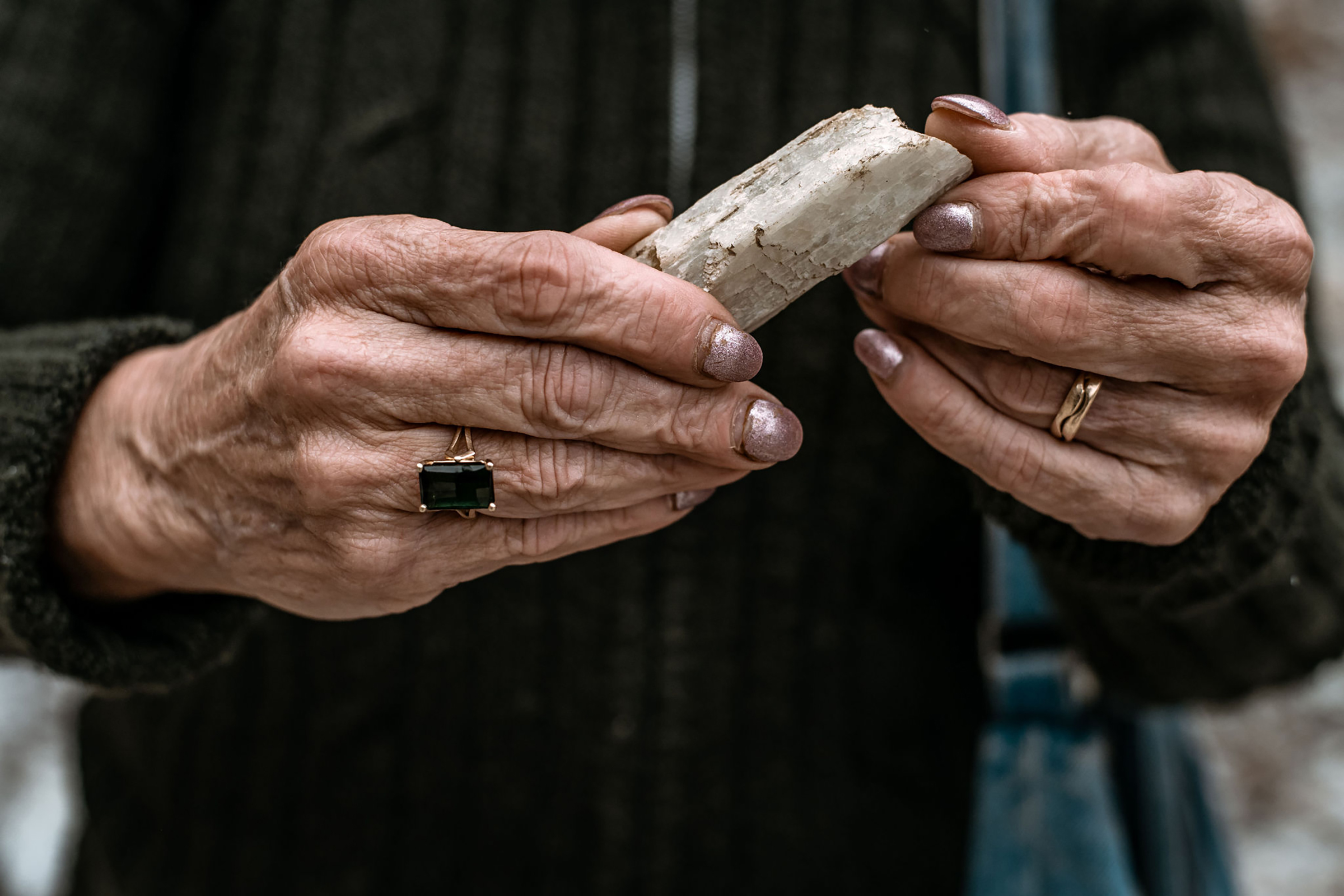 Mary Freeman holds a spodumene crystal, which contains lithium, found in the test pit she and her husband Gary own in Newry, Maine, on June 6. (Garrick Hoffman—The Maine Monitor)