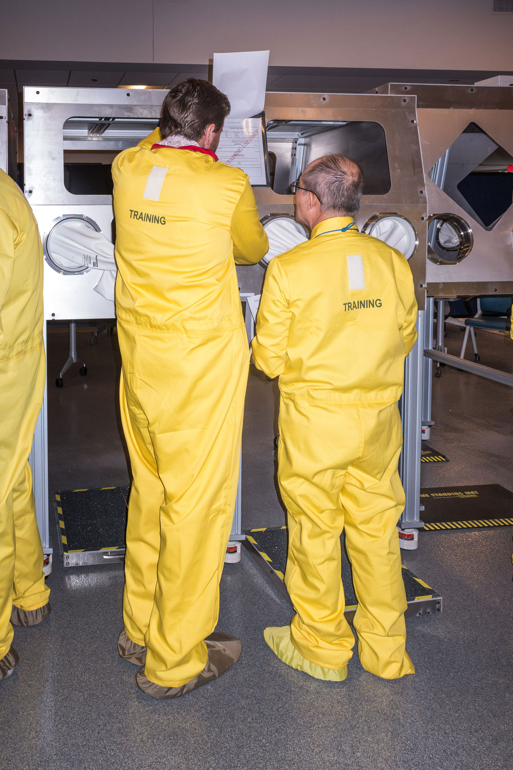 Employees training to use glove boxes to handle plutonium, in the NET facility