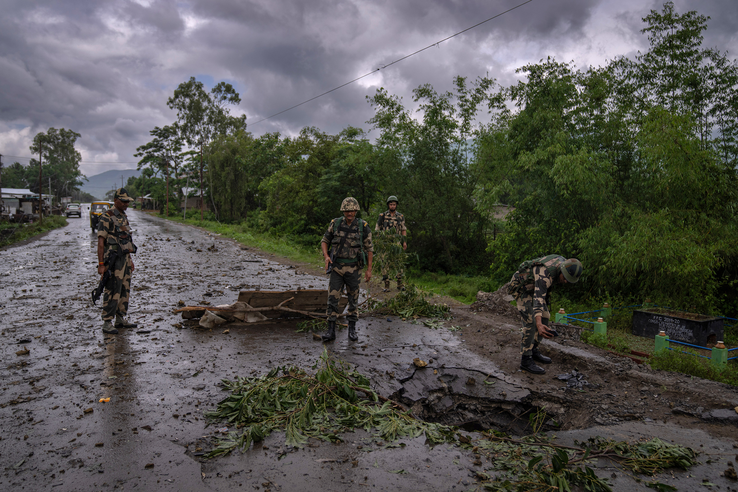 Indian paramilitary soldiers inspect the site of a car bomb explosion in Kwakta, some 50 kilometers from Imphal, capital of the northeastern Indian state of Manipur on June 22. Manipur is caught in a deadly conflict between two ethnic communities that have armed themselves and launched brutal attacks against one another. The clashes, which have left at least 120 dead by the authorities' conservative estimates, persist despite the army’s presence. (Altaf Qadri—AP)