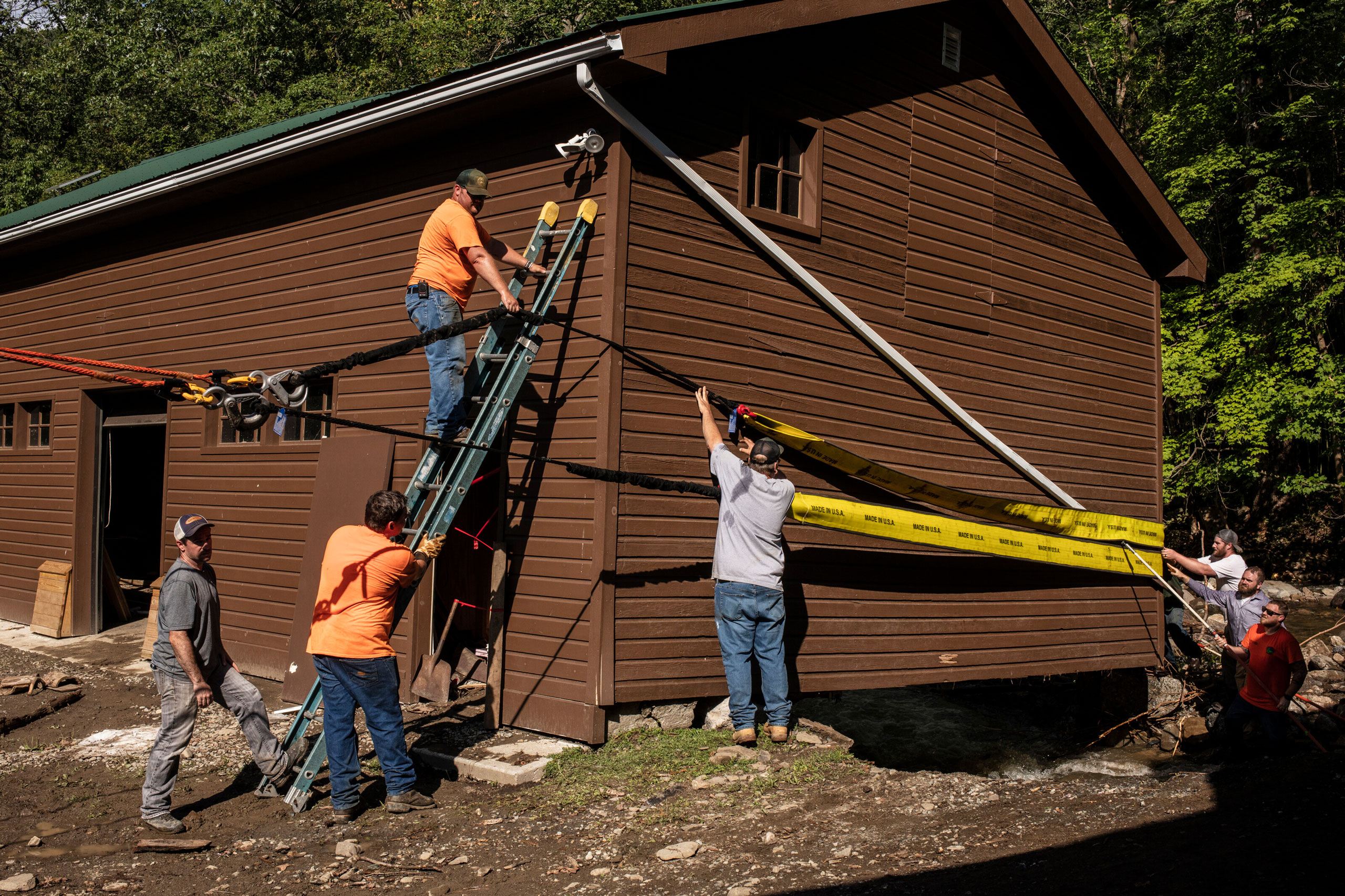 Workers prepare to move a building out of the creek after flash flooding left damage in Black Rock Forest in Cornwall, N.Y., on July 10, 2023. (Bryan Anselm—The New York Times/Redux)