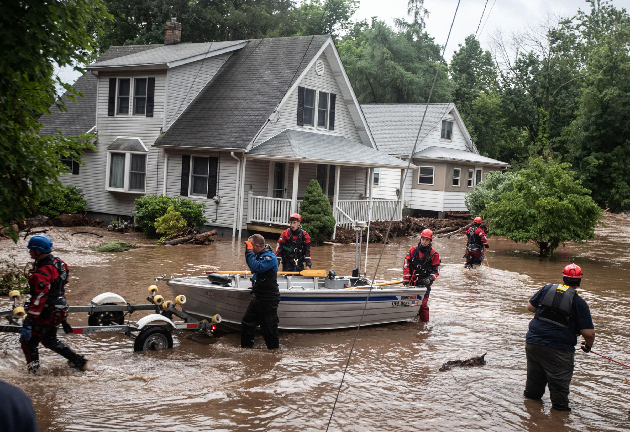 Emergency personnel maneuver a boat which was used to rescue residents of flooded homes