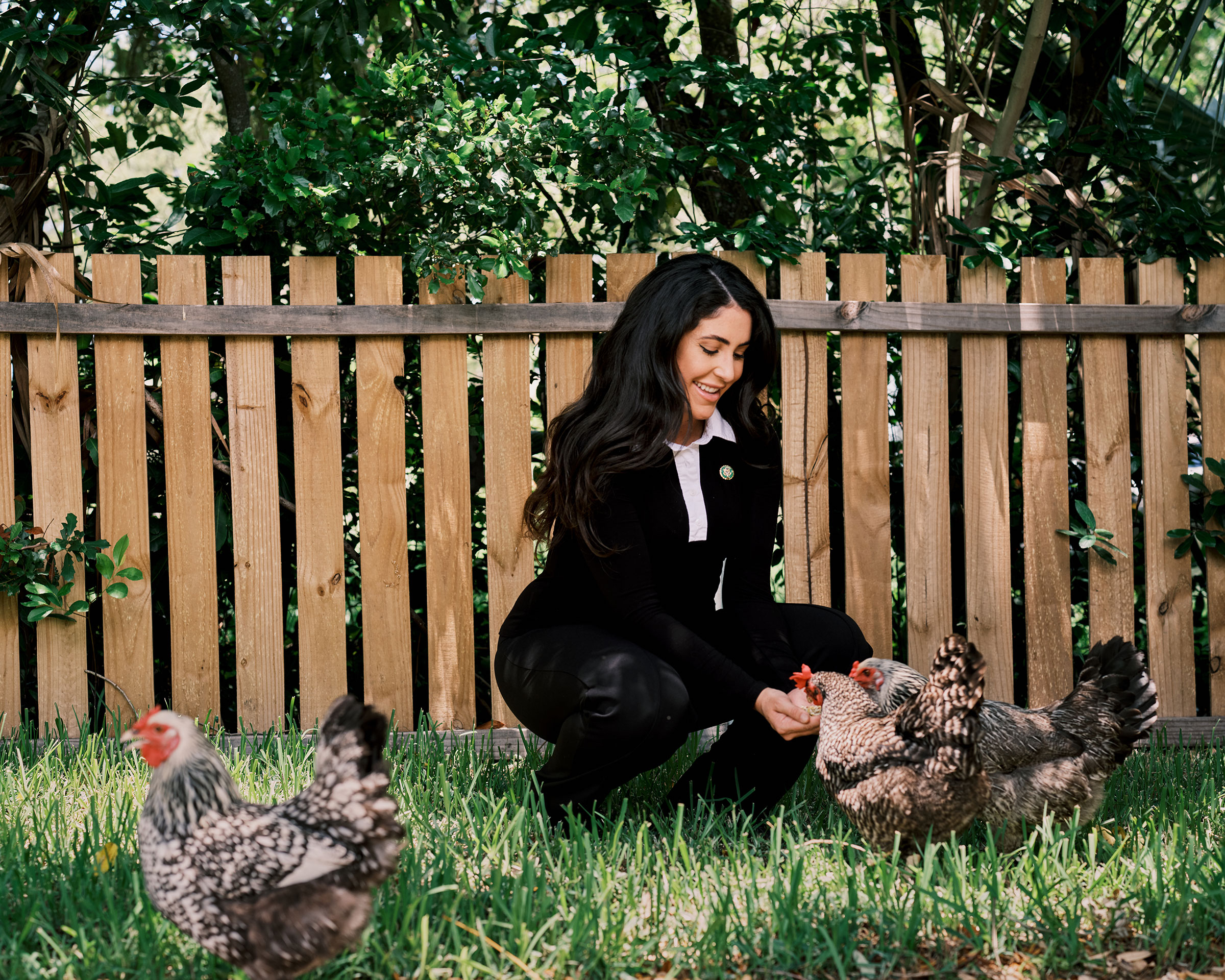 Luna feeds her chickens at home after returning from the office on July 6. (Zack Wittman for TIME)