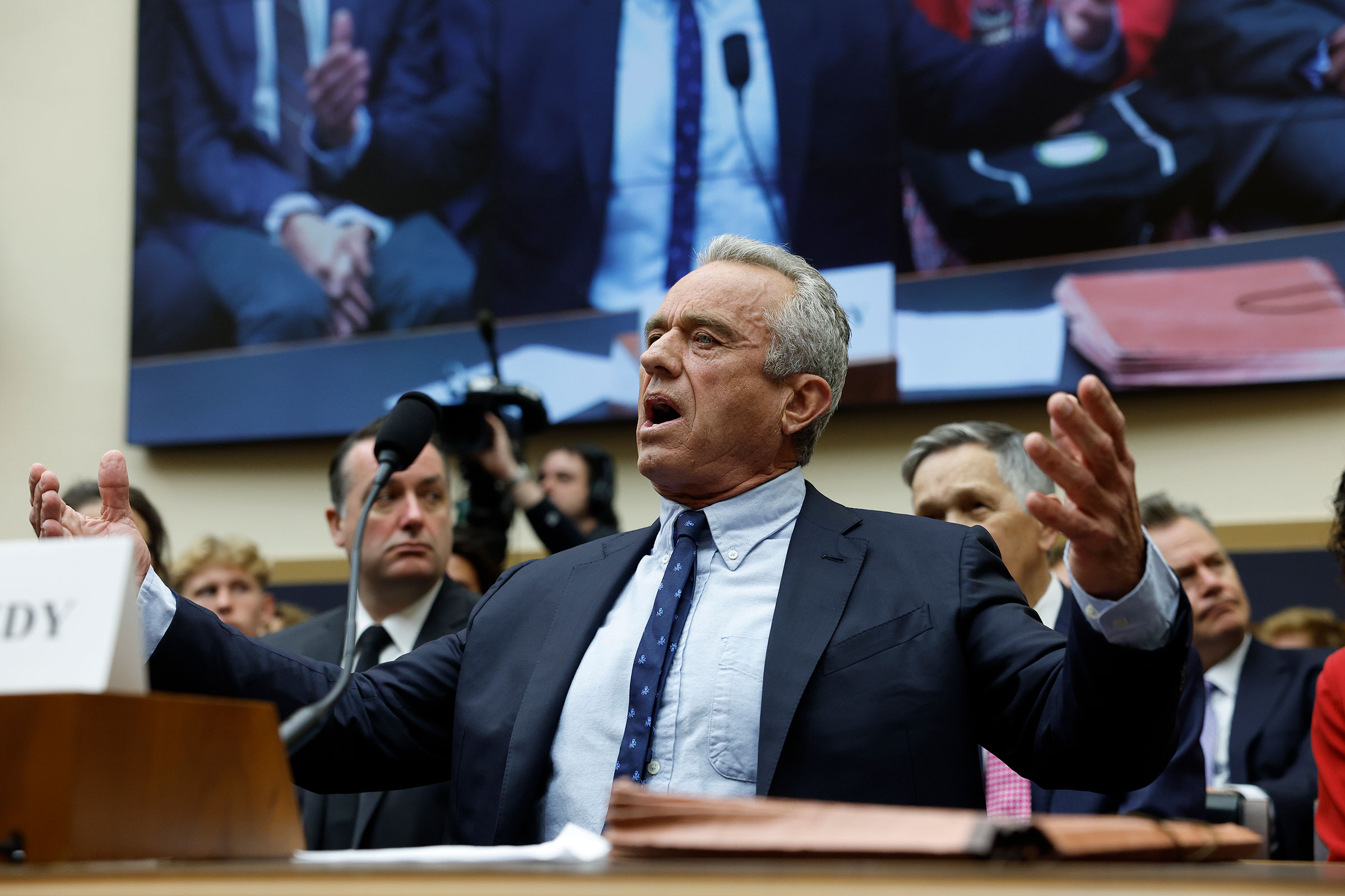 Robert F. Kennedy Jr. gestures his arms out as he speaks into a microphone during testimony at a House Judiciary Subcommittee meeting