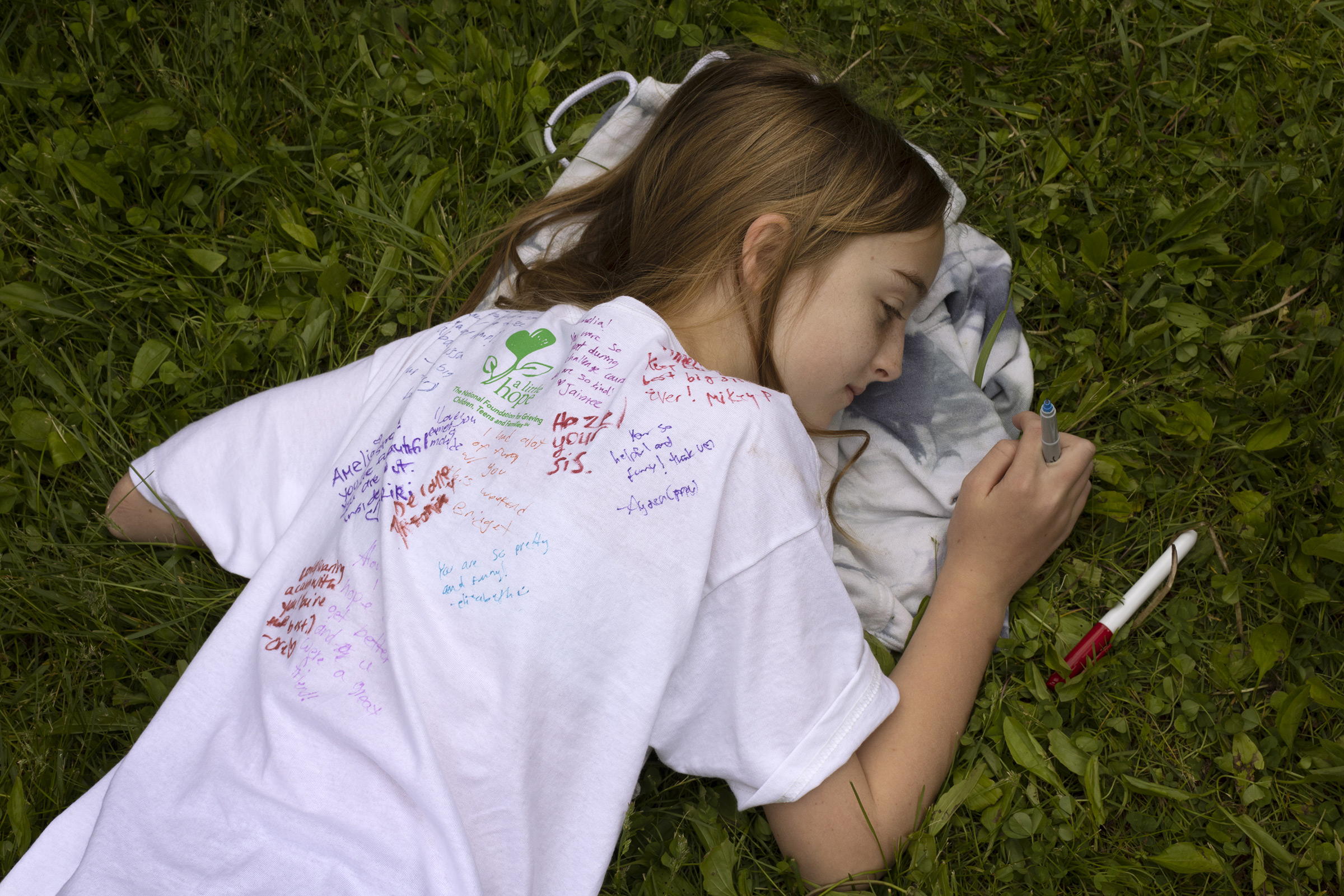 On the last day of Comfort Zone Camp, kids sign one another's shirts. Pictured here is camper Amelia Smith.