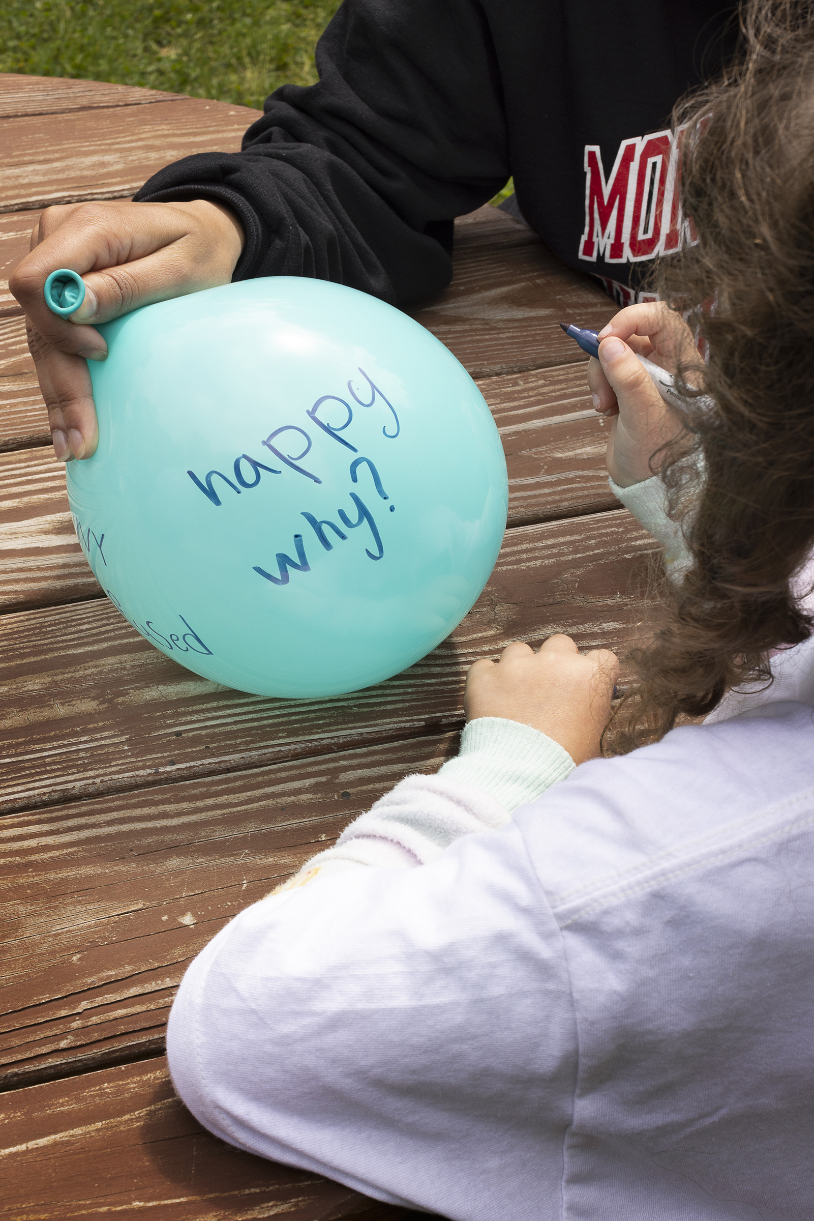 A camper writes on a balloon during a healing-circle exercise.