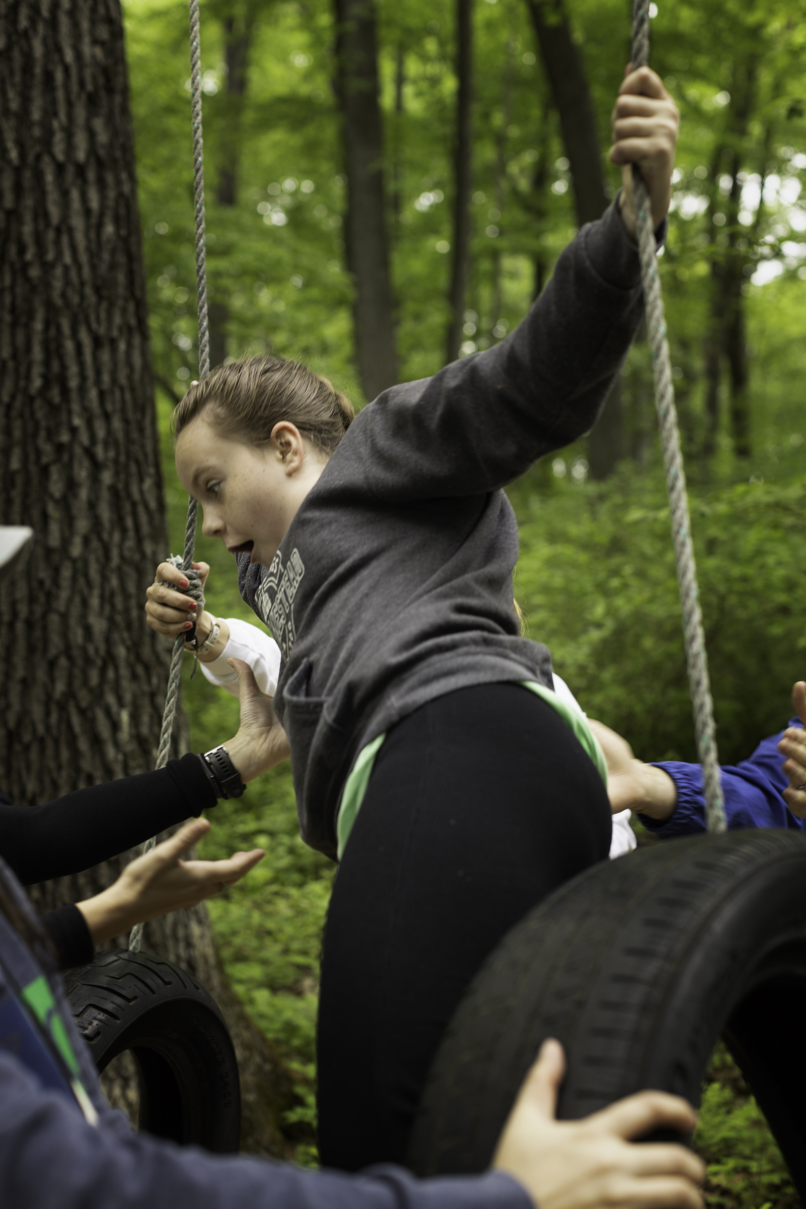 Campers and buddies help camper Reille Heil on an obstacle course.