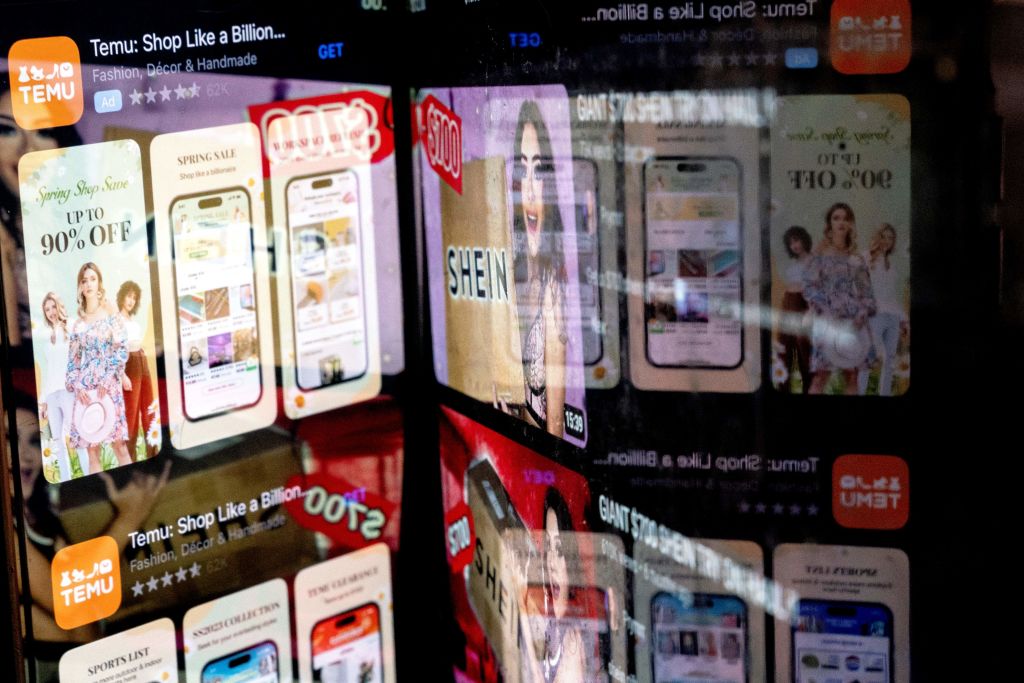 Temu's app in the App Store reflected in videos of Shein consumers, in Washington, D.C., Feb. 23, 2023. (Stefani Reynolds—AFP/Getty Images)