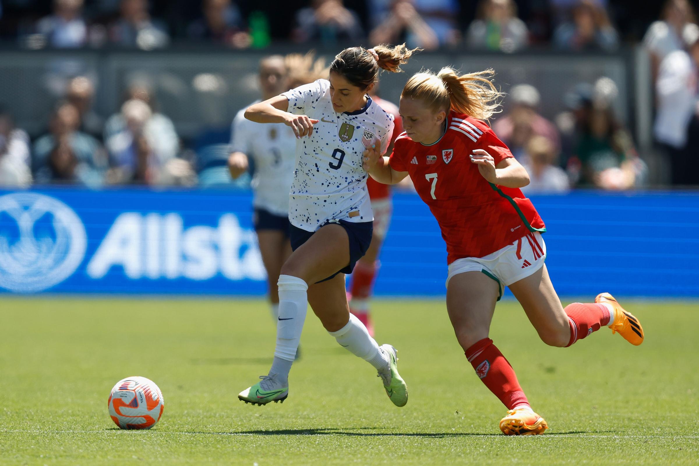 Savannah DeMelo competes for the ball against Ceri Holland of Wales