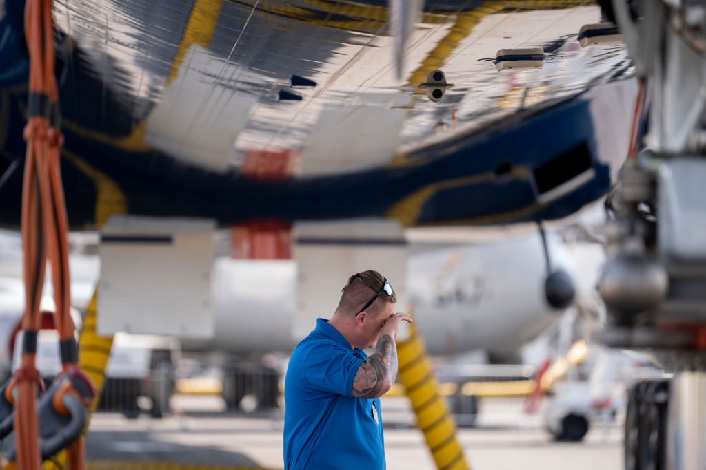 A Boeing employee stands in the shade during the UK heat wave 18th July 18 2022, at Farnborough, England.