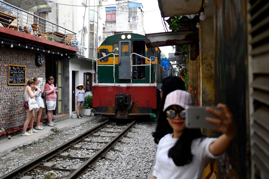 A woman takes a selfie as a train passes by in Hanoi, Vietnam, on June 8, 2019. (Manan Vatsyayana—AFP/Getty Images)