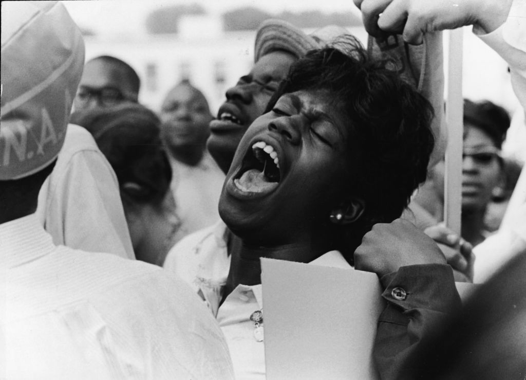 A Black woman stands in a crowd and yells, "Freedom!" when asked to yell so loud it will be heard all over the world at the March on Washington in Washington, DC on August 28, 1963.  (Express Newspapers—Archive Photos/Getty Images)