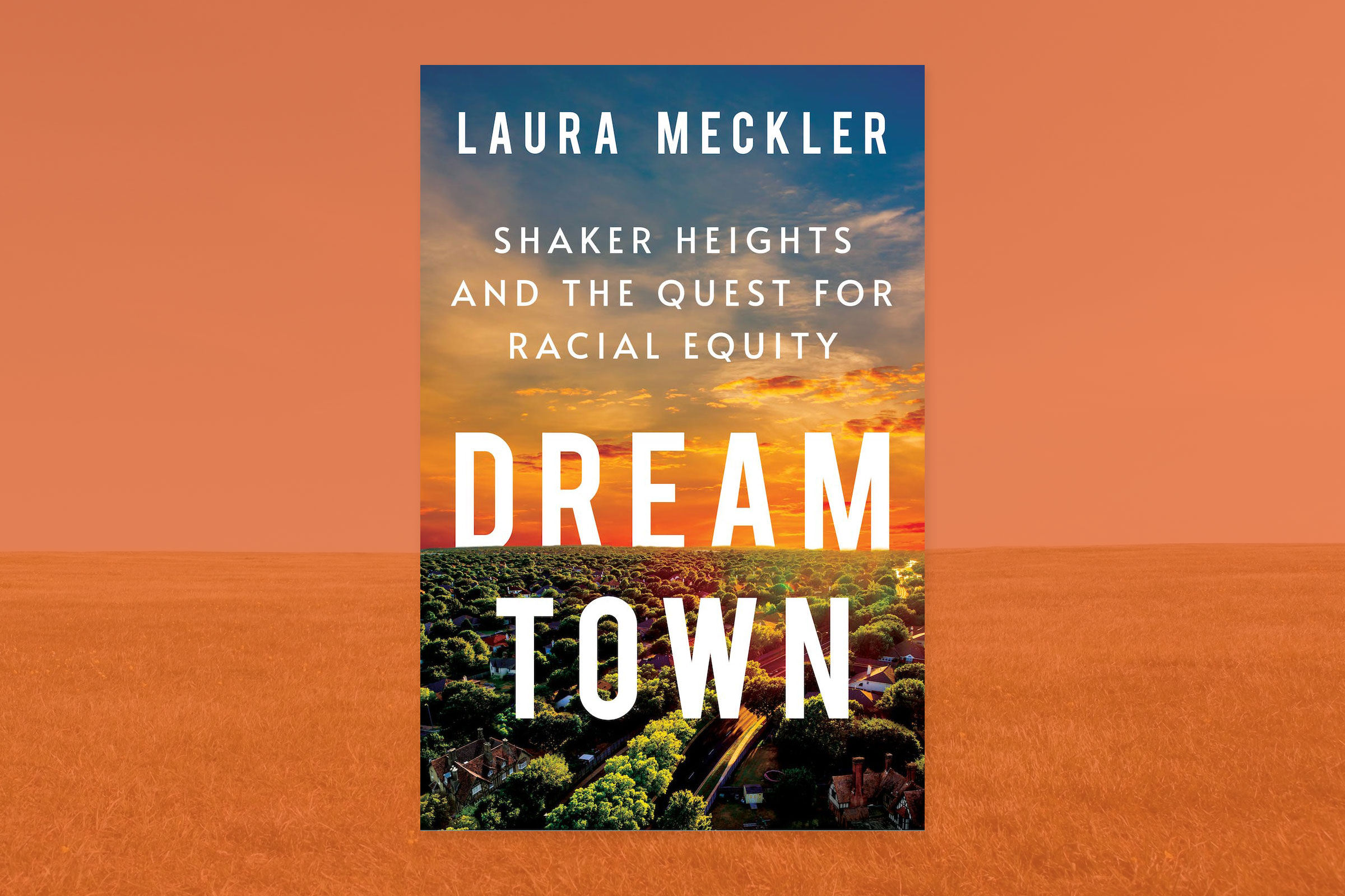The cover for Laura Meckler's book Dream Town that shows a overhead view of a town with trees streets and houses with an orange sunset behind it