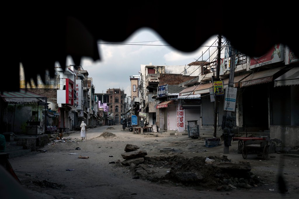 An elderly man walks in an area deserted after communal clashes in Nuh, Haryana state, India, on Aug. 1.