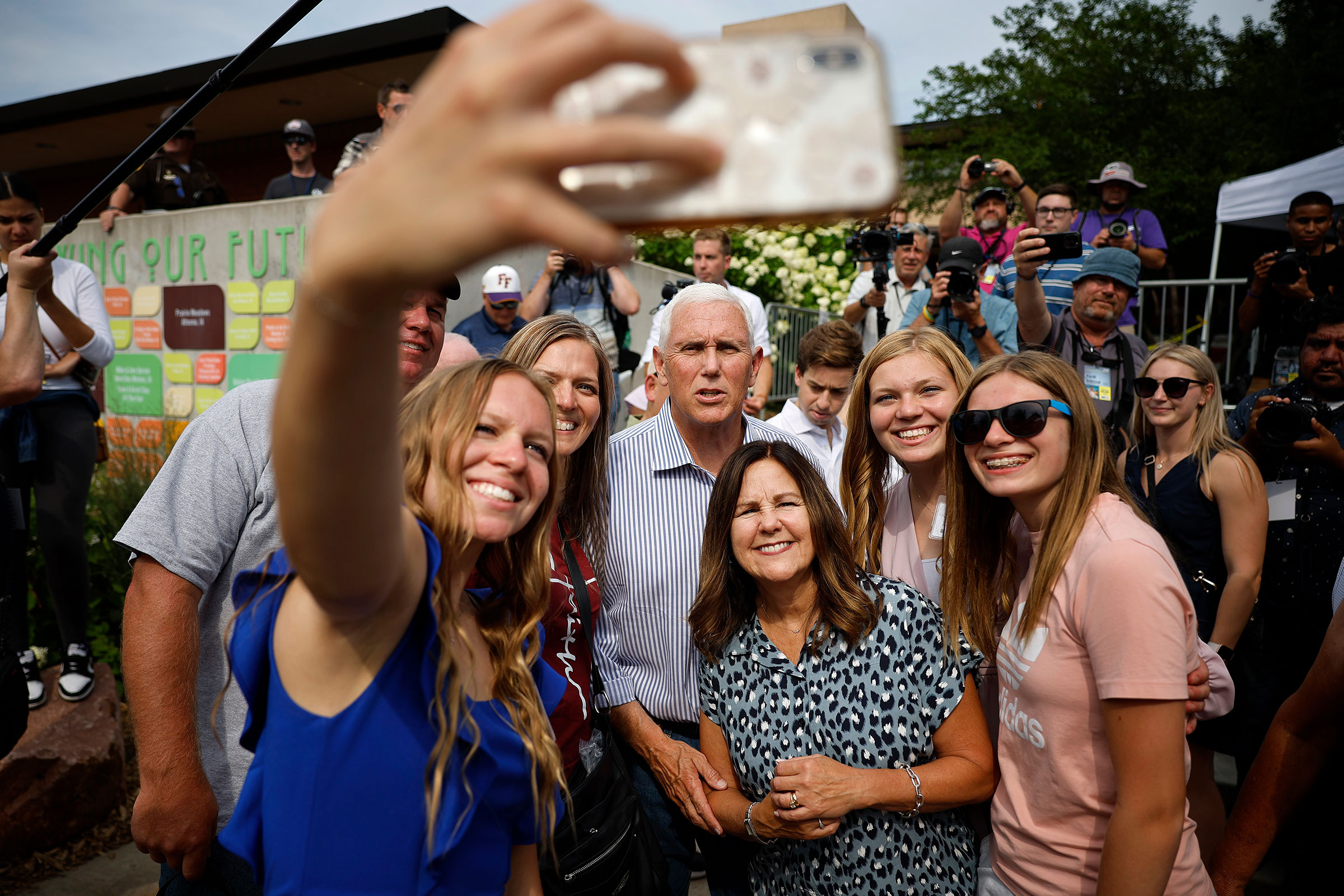 Republican presidential candidate former Vice President Mike Pence and his wife Karen Pence pose for selfies with supporters on Aug. 10. (Chip Somodevilla—Getty Images)