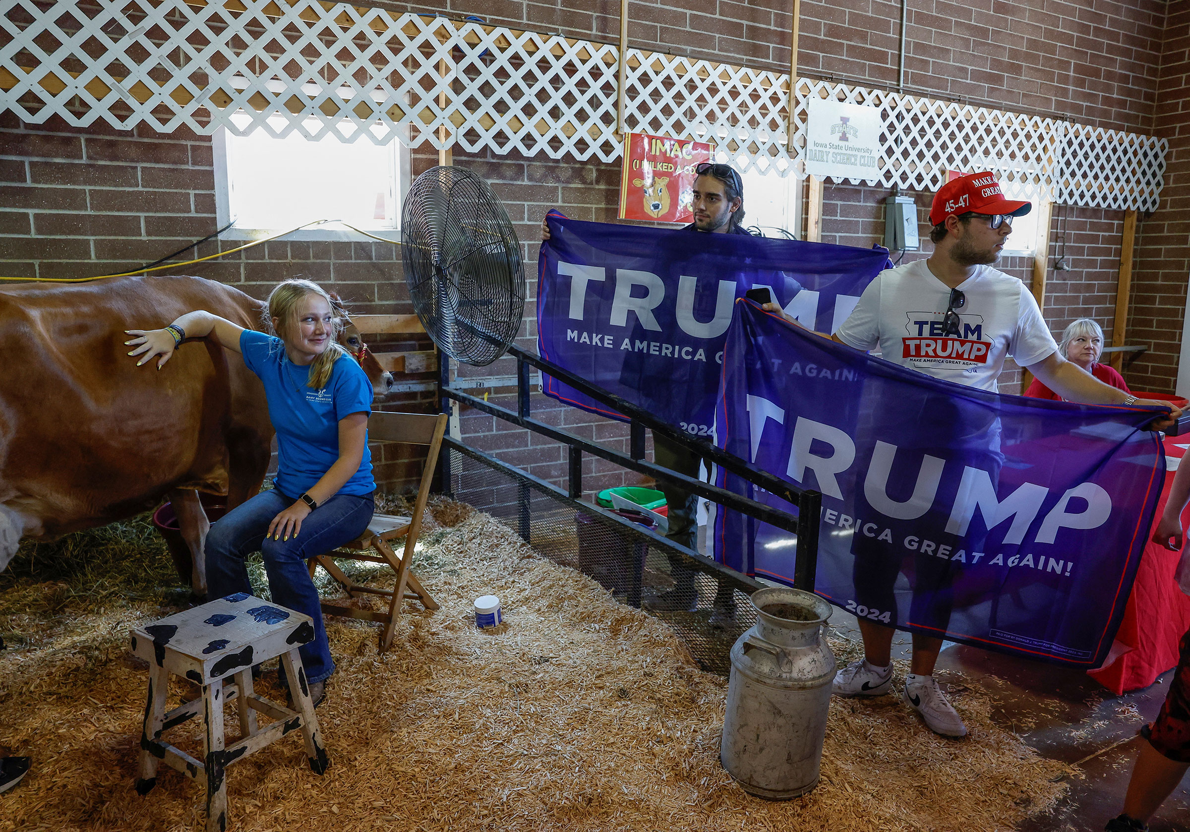 Trump campaign workers hold Trump flags for a photo opportunity with Kari Lake, at the Iowa State Fair