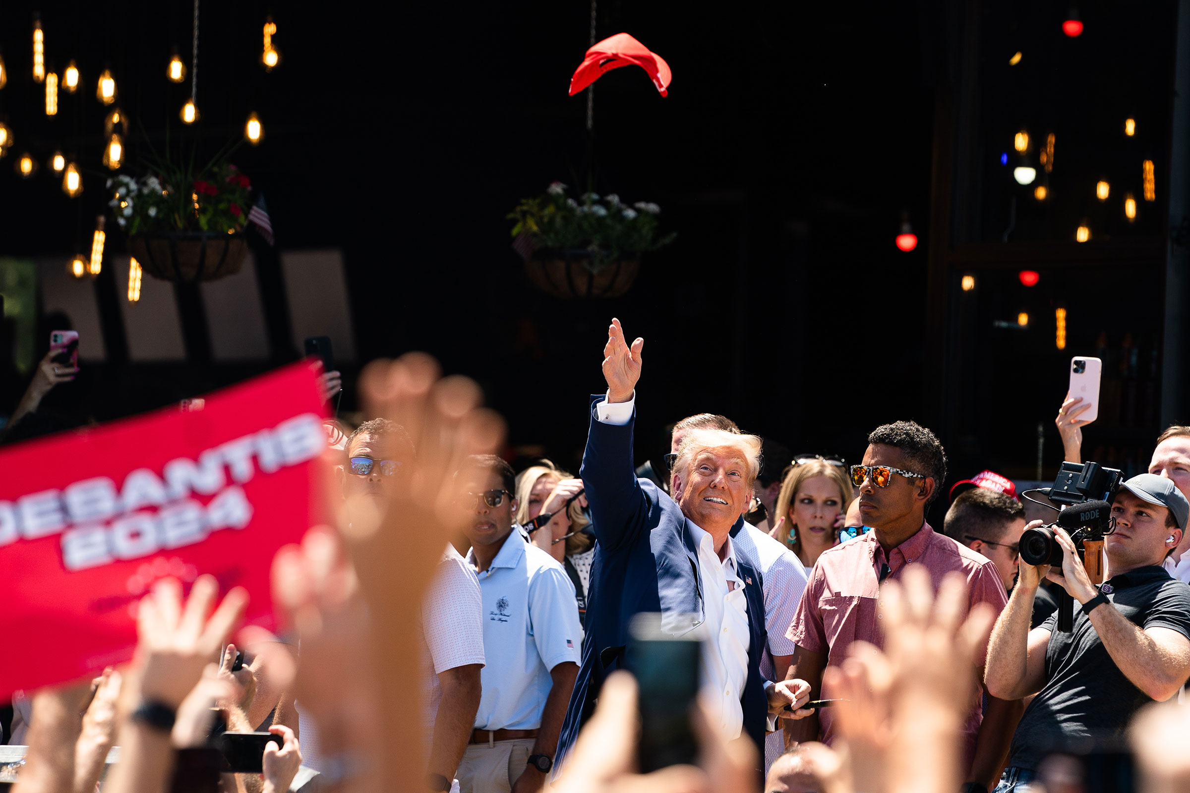 Former President Donald Trump tosses a hat in the air while supporters cheer for him on Aug. 12. (Demetrius Freeman—The Washington Post/Getty Images)