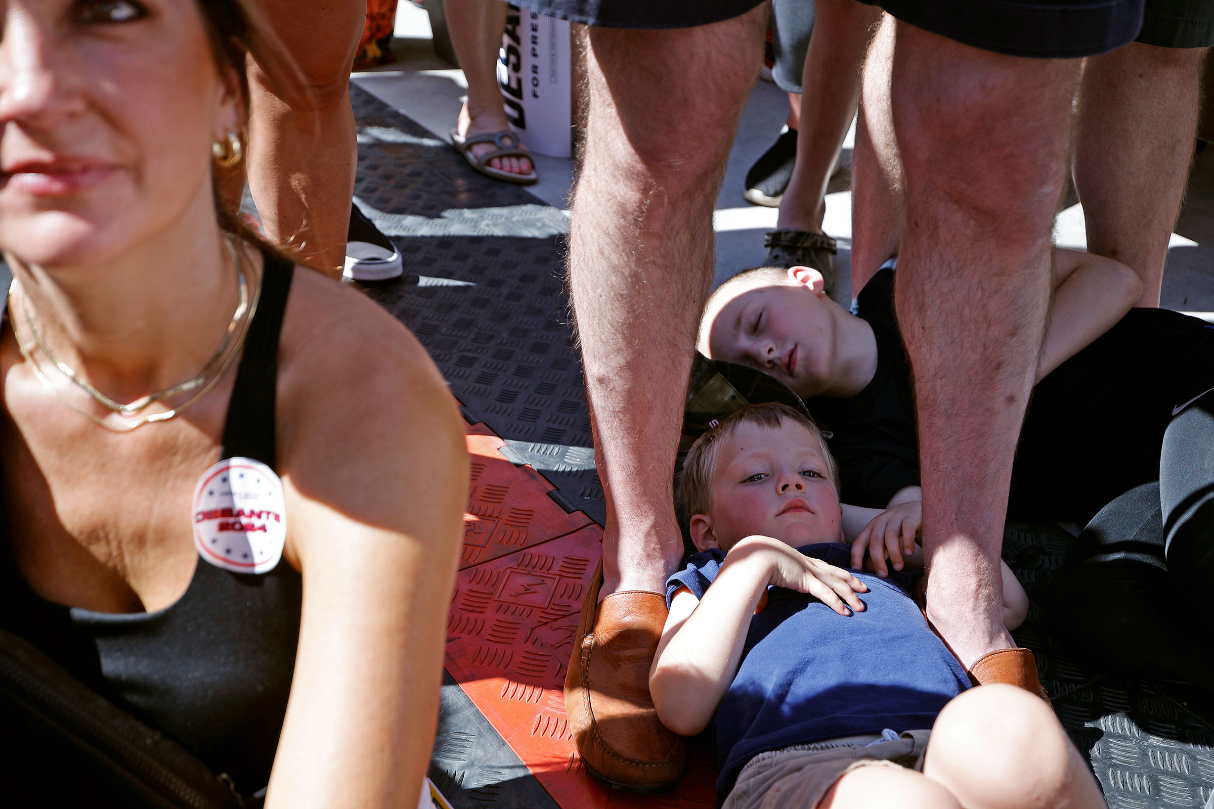 Children lay on the ground while listening to Florida Governor Ron DeSantis participate in a "Fair-Side Chat" on Aug. 12. (Chip Somodevilla—Getty Images)