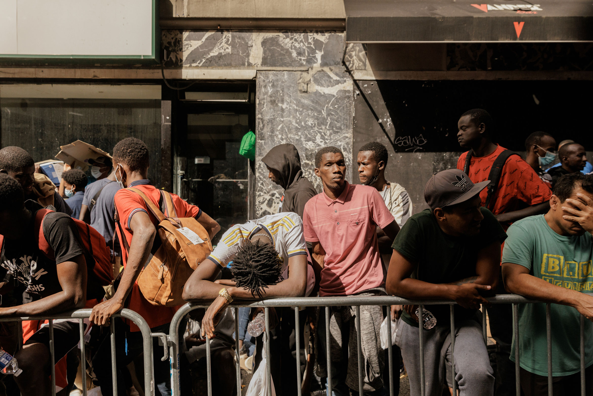 Migrants waiting to be processed queue outside of the Roosevelt Hotel in Manhattan, on Aug. 1, 2023.  (Jeenah Moon—The New York Times/Redux)