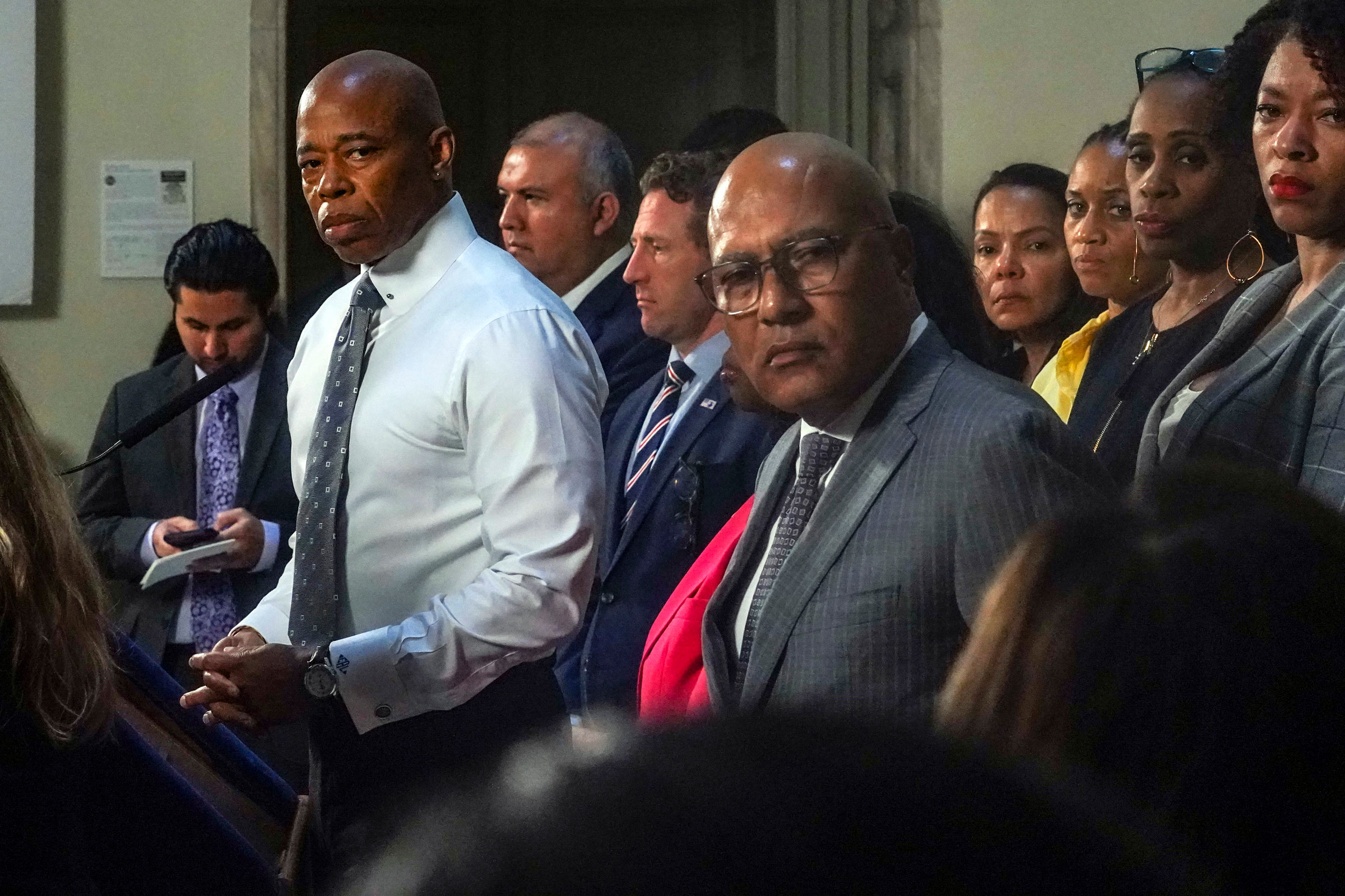 New York Mayor Eric Adams, left, and city officials listen to a reporter’s question during a City Hall press conference, on Aug. 9, 2023. (Bebeto Matthews—AP)
