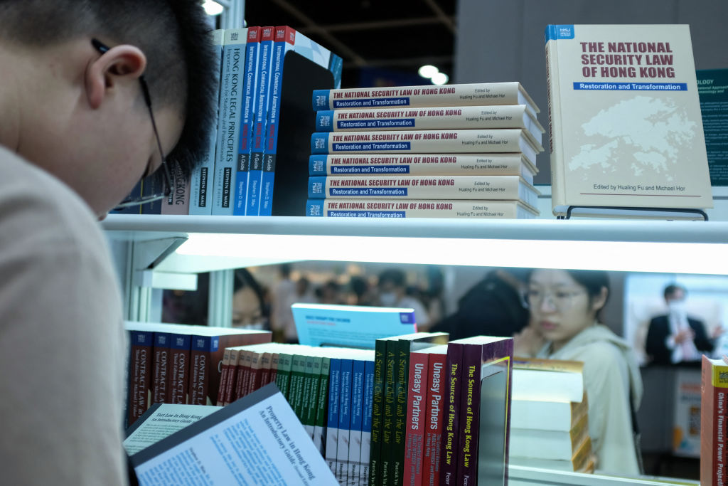 Visitors read at a booth displaying the books on the national security law of Hong Kong at the 33rd Hong Kong Book Fair in the Wan Chai area of Hong Kong on July 19, 2023.