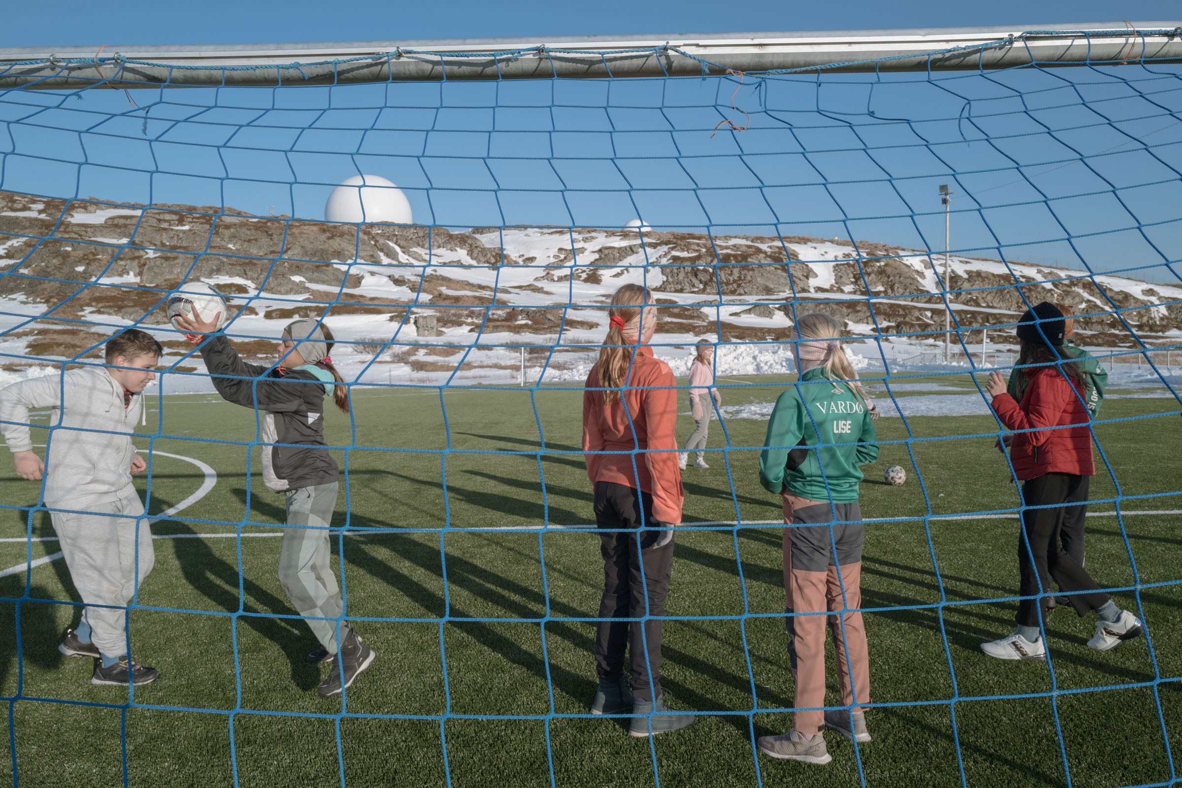 Children play soccer near the GLOBUS radar systems.