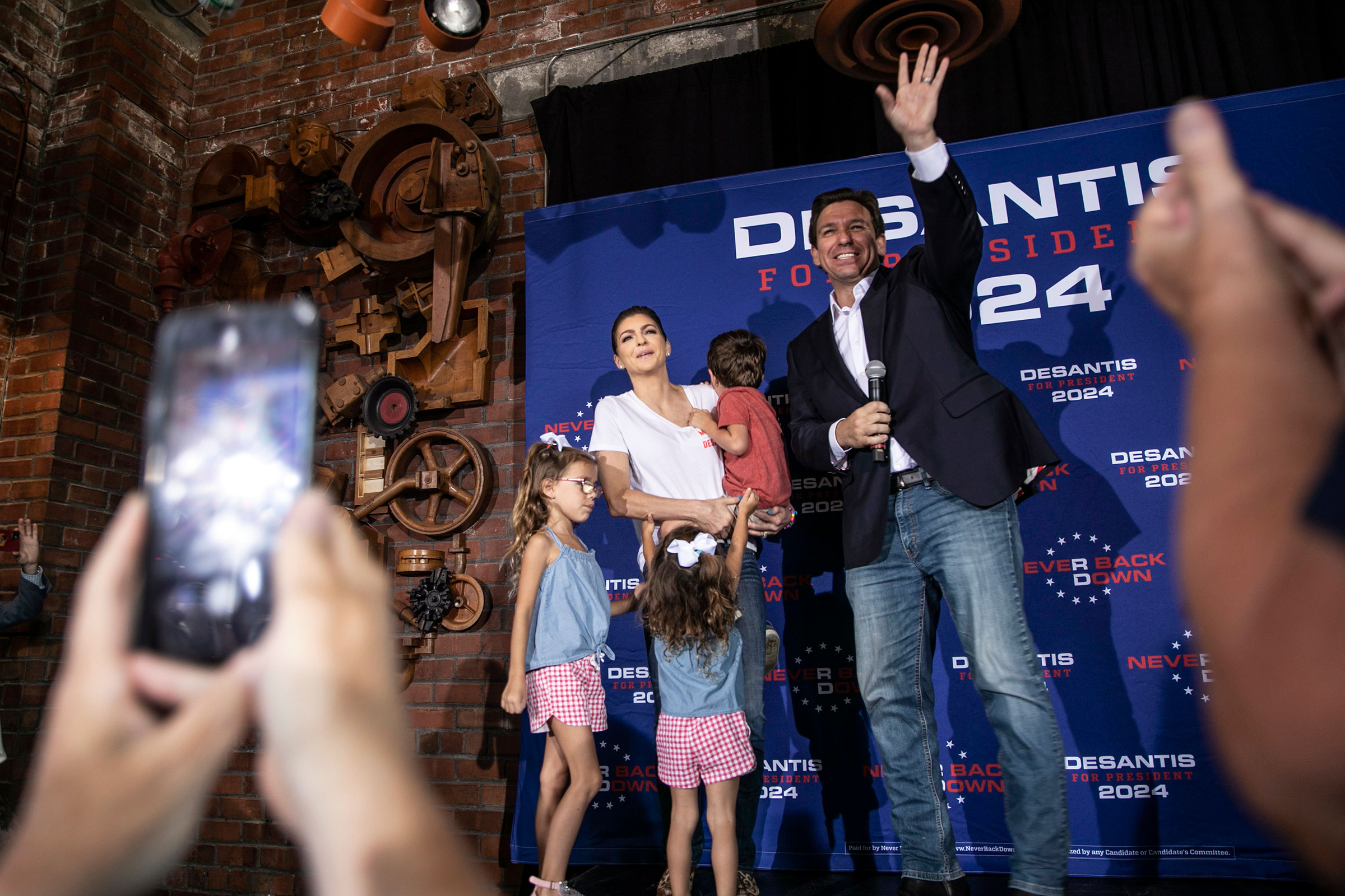 DeSantis and his family wave to audience members at Iowa River Power Restaurant in Iowa City, on Aug. 10, 2023. (Geoff Stellfox—AP)