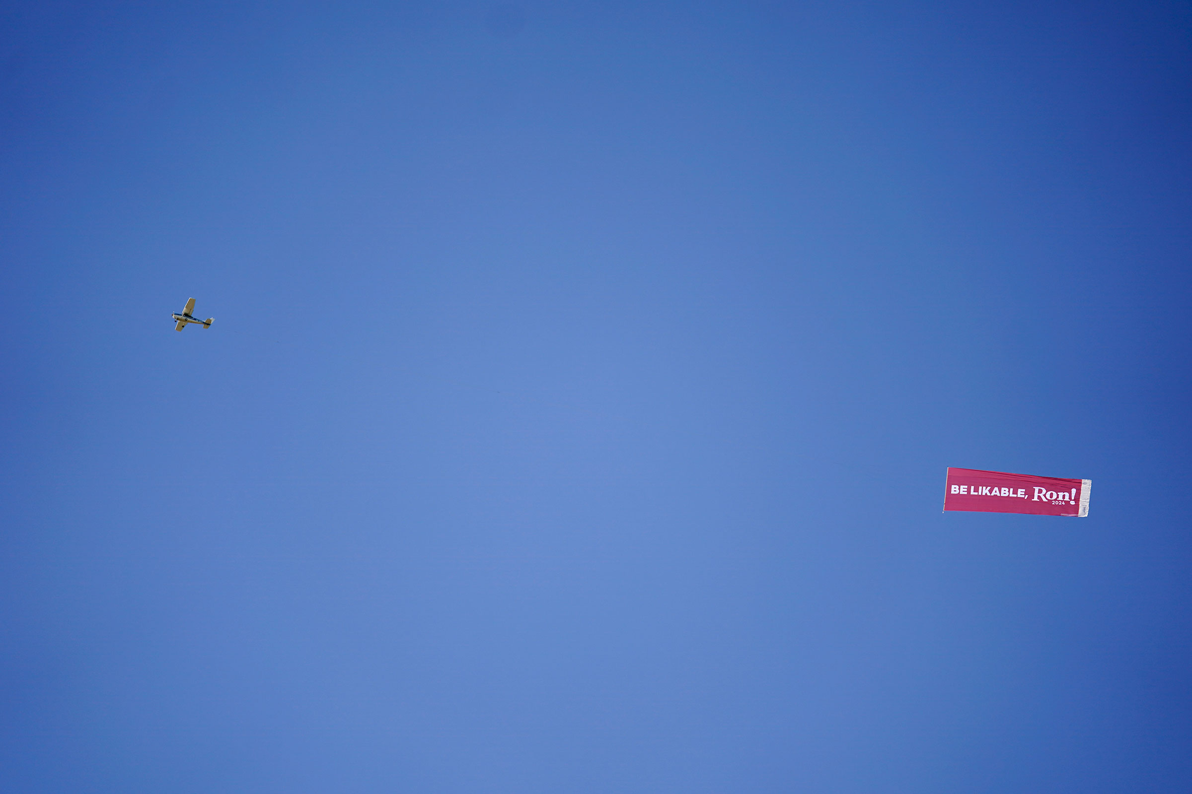 A plane flies over the Iowa State Fair pulling a banner with a message for DeSantis on, Aug. 12, 2023. (Jeff Roberson—AP)