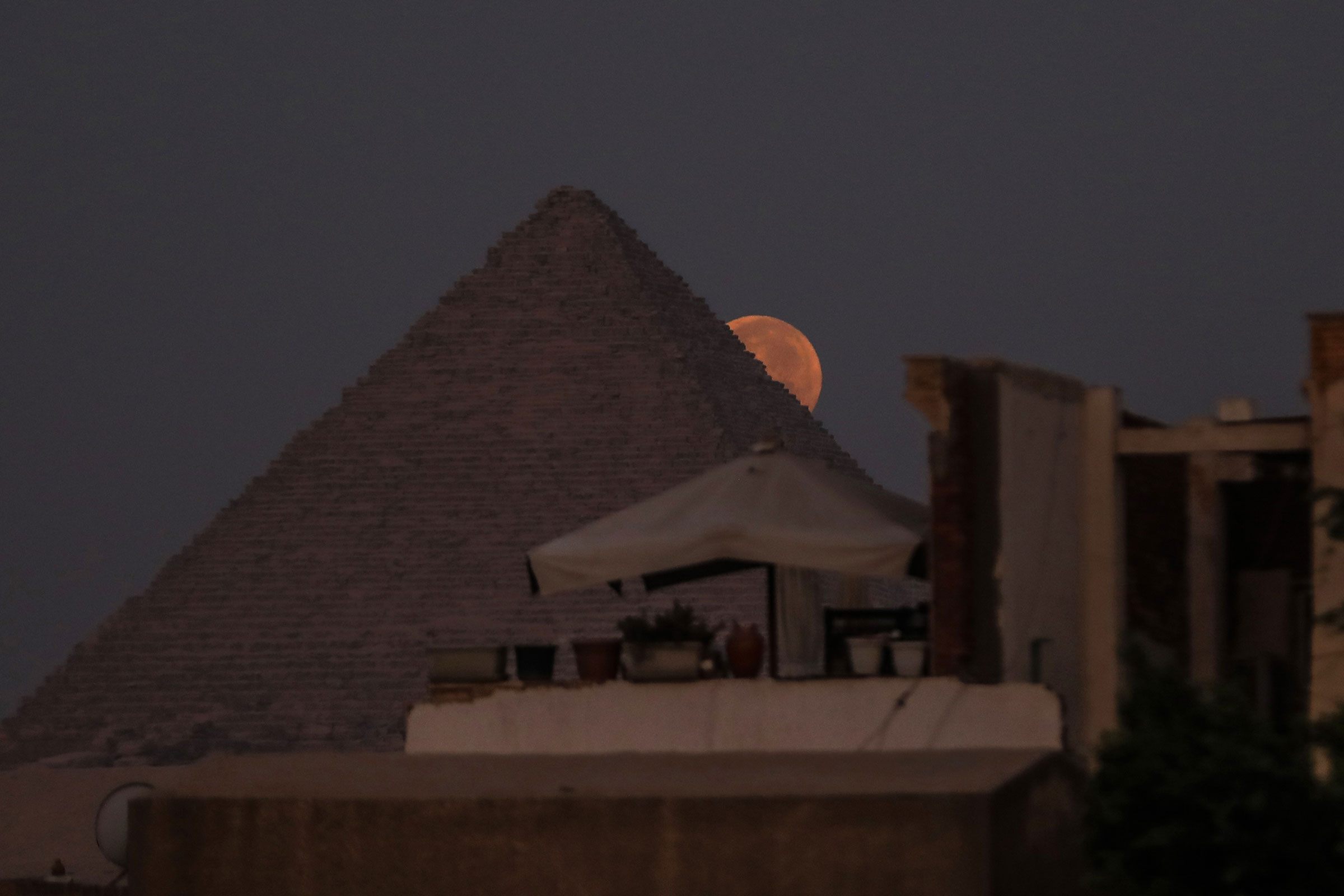 A view of the super blue moon behind the Pyramids of Giza in Egypt on Aug. 31, 2023. (Mohamed Elshahed—Anadolu Agency/Getty Images)