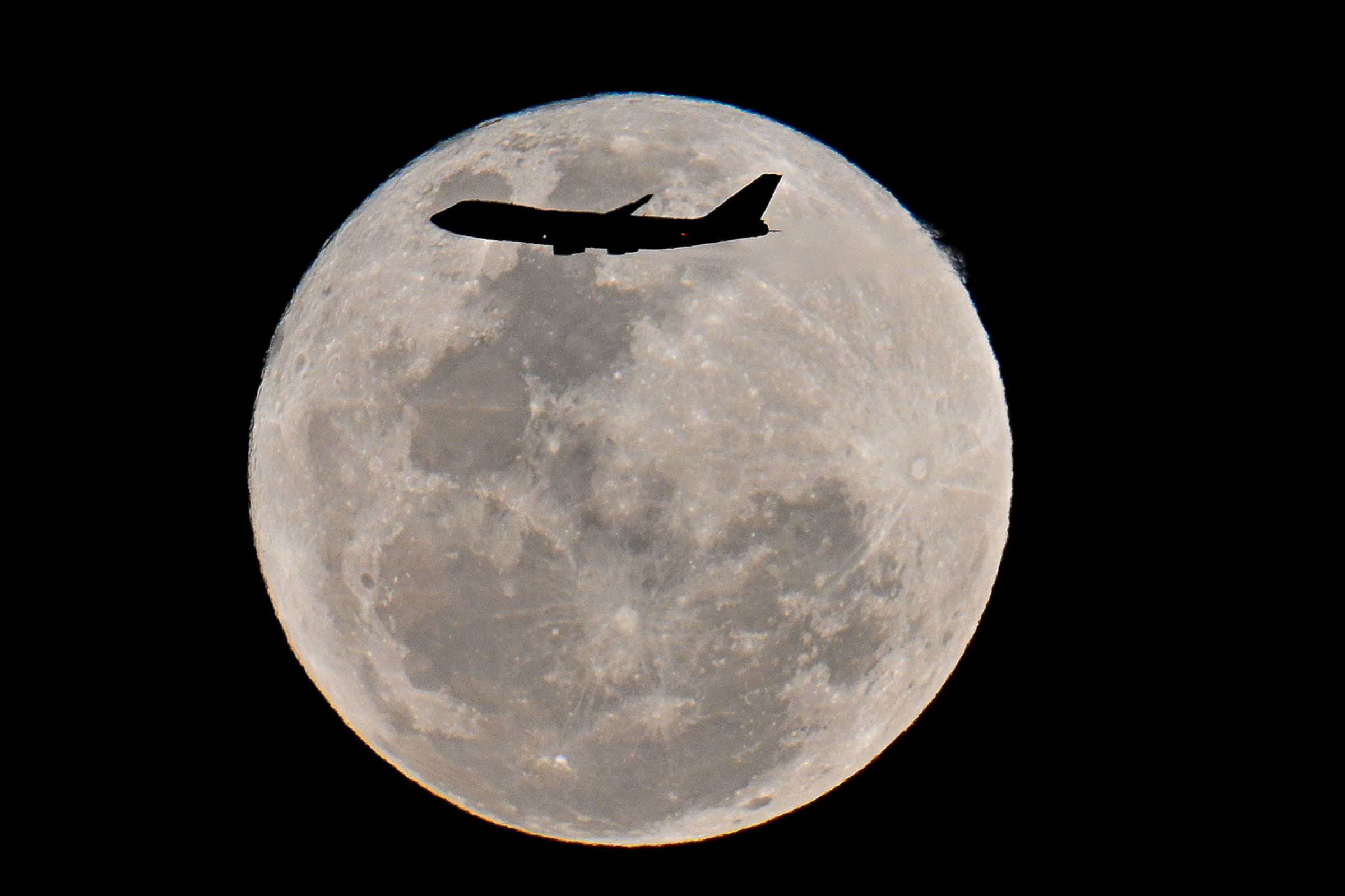 A plane flying by the super blue moon in Sydney in Australia on Aug. 31, 2023.