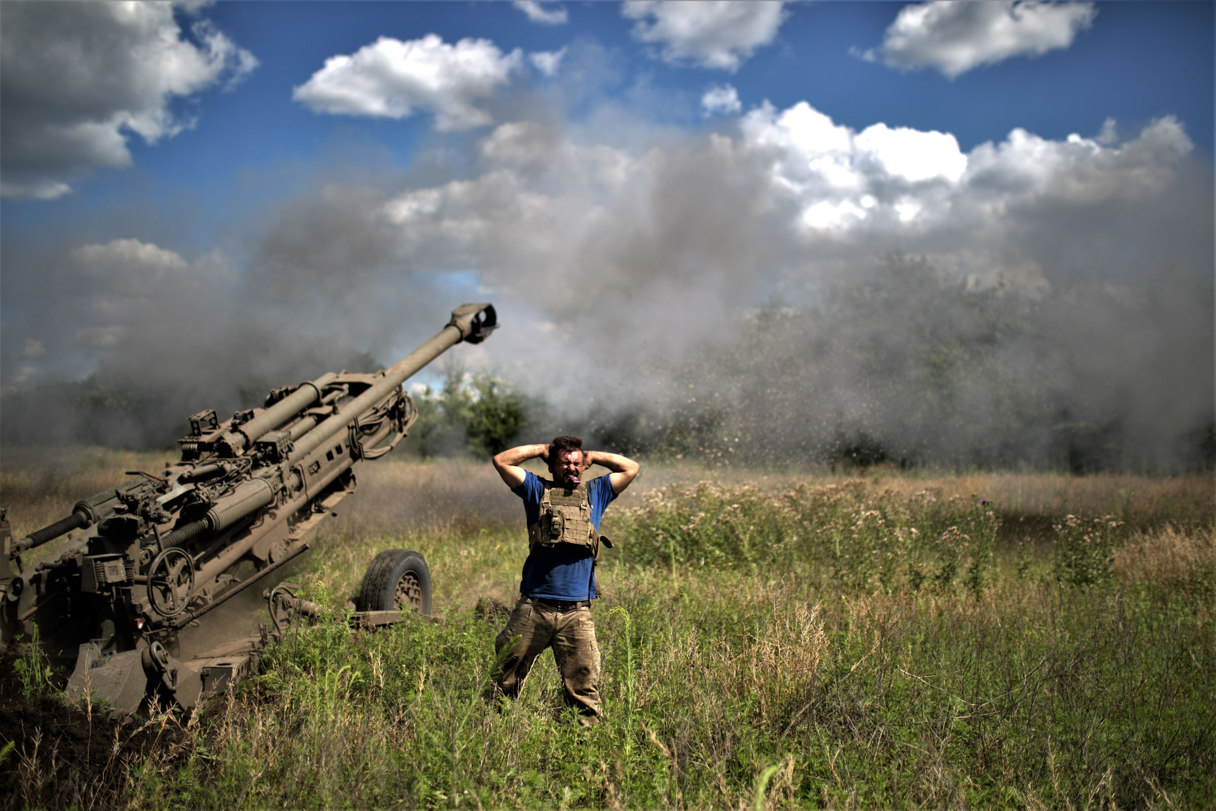 A soldier covers his ears after the firing of an air cannon as Ukrainian artillery division supports soldiers in a counteroffensive on the Zaporizhzhya frontline with M777 in Zaporizhzhya, Ukraine on July 16, 2023.  (Gian Marco Benedetto—Anadolu Agency/Getty Images)