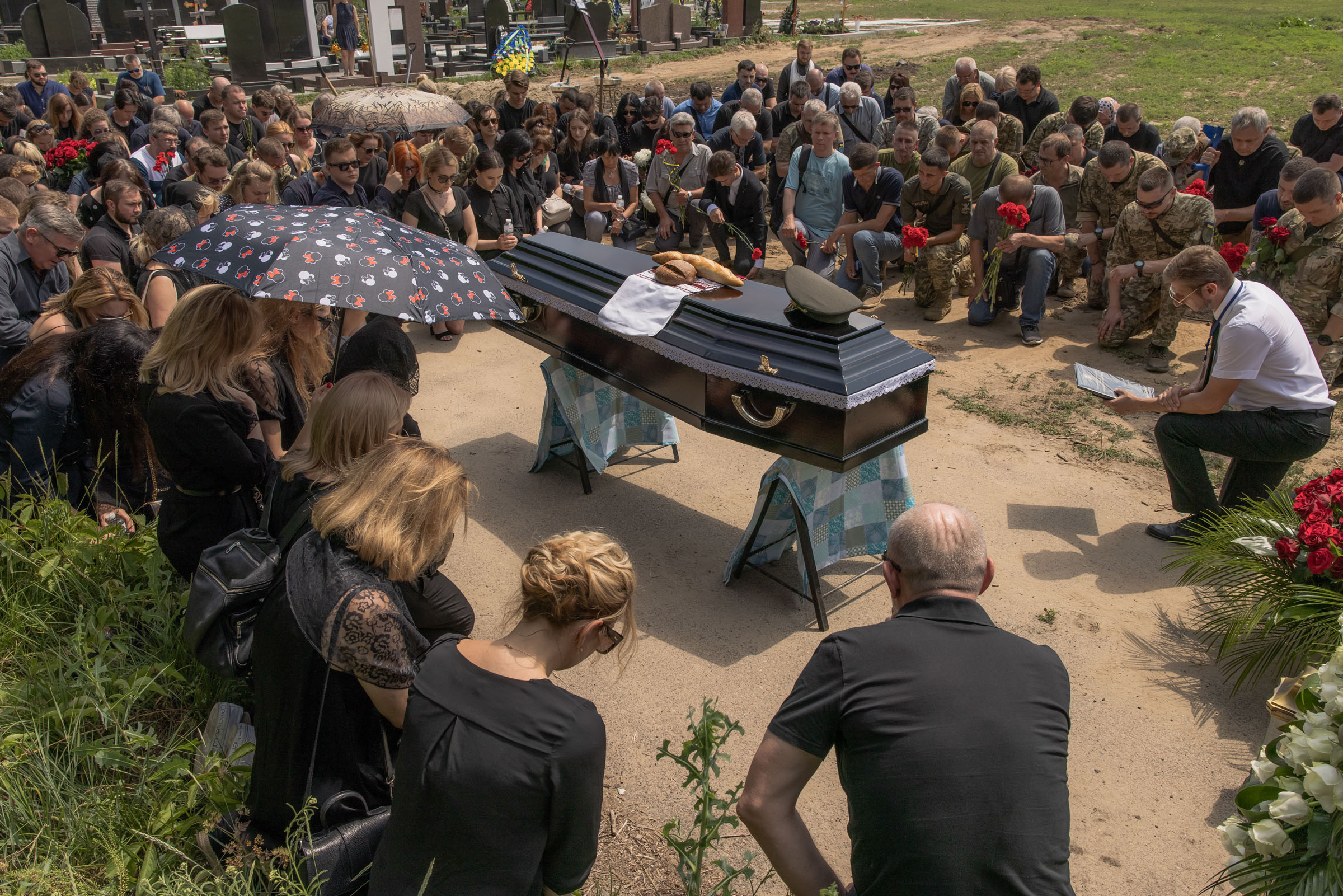 Relatives and friends kneel down next to the coffin of Anton Klitnyi, a Ukrainian serviceman, who was killed fighting Russian troops in the Zaporizhzhia region, during the funeral on July 2, 2023 in Kyiv, Ukraine.  (Roman Pilipey—Getty Images)