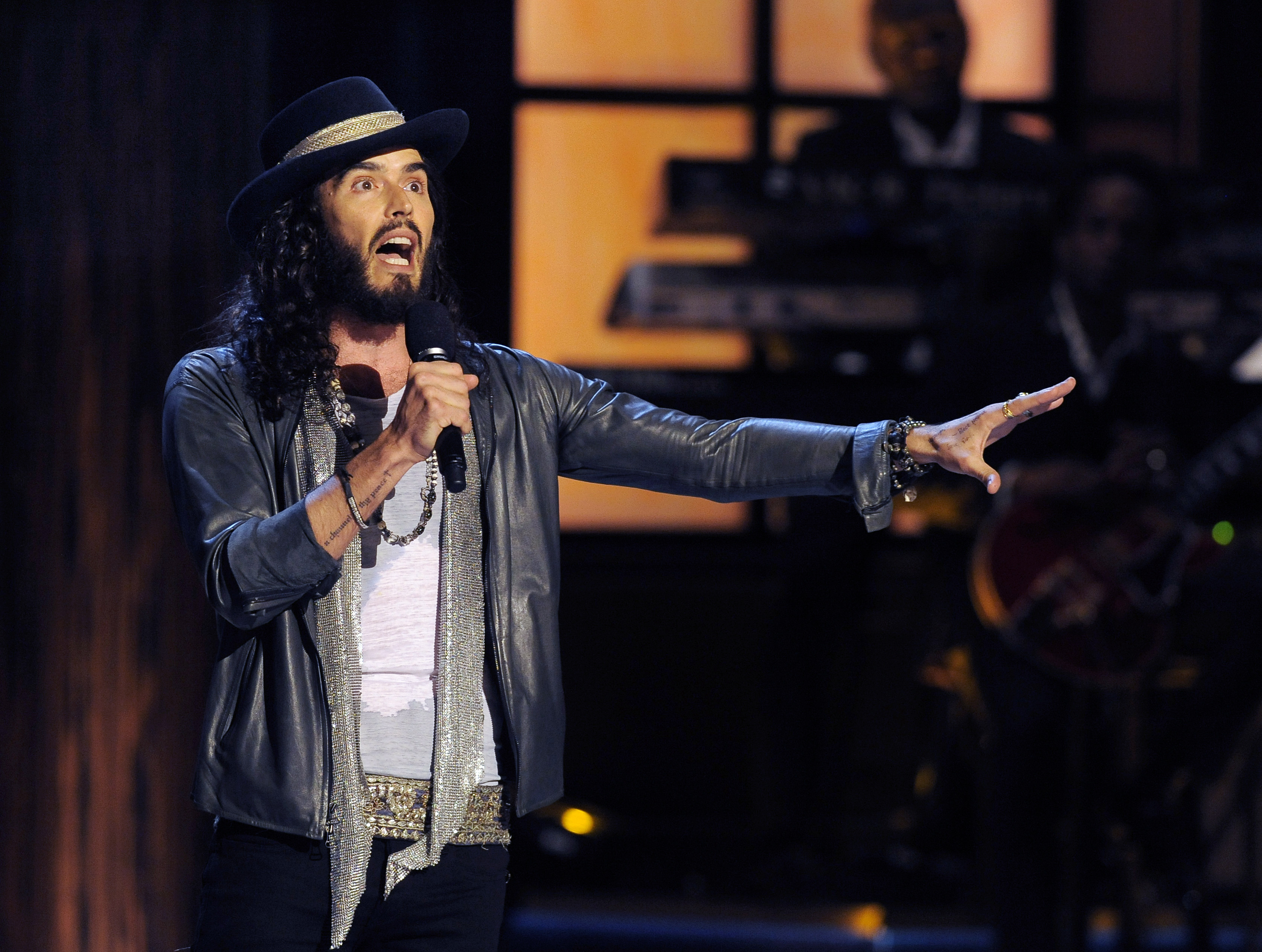 Russell Brand, here performing on stage, has denied allegations of sexual assault. (Chris Pizzello/Invision / AP)