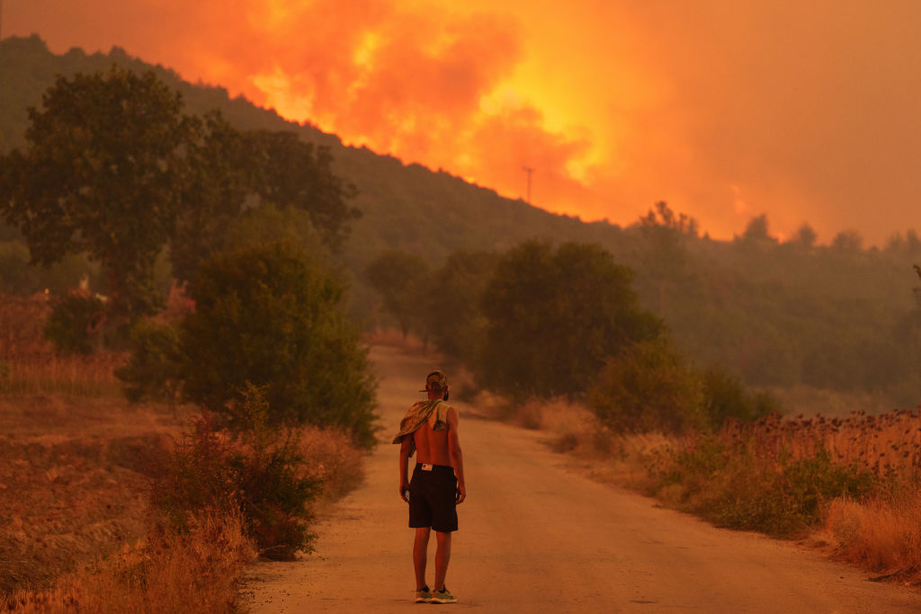 A local resident looks on at the wildfire approaching the village of Avantas, northeast of Alexandroupolis, Greece, on Monday, Aug. 21, 2023.