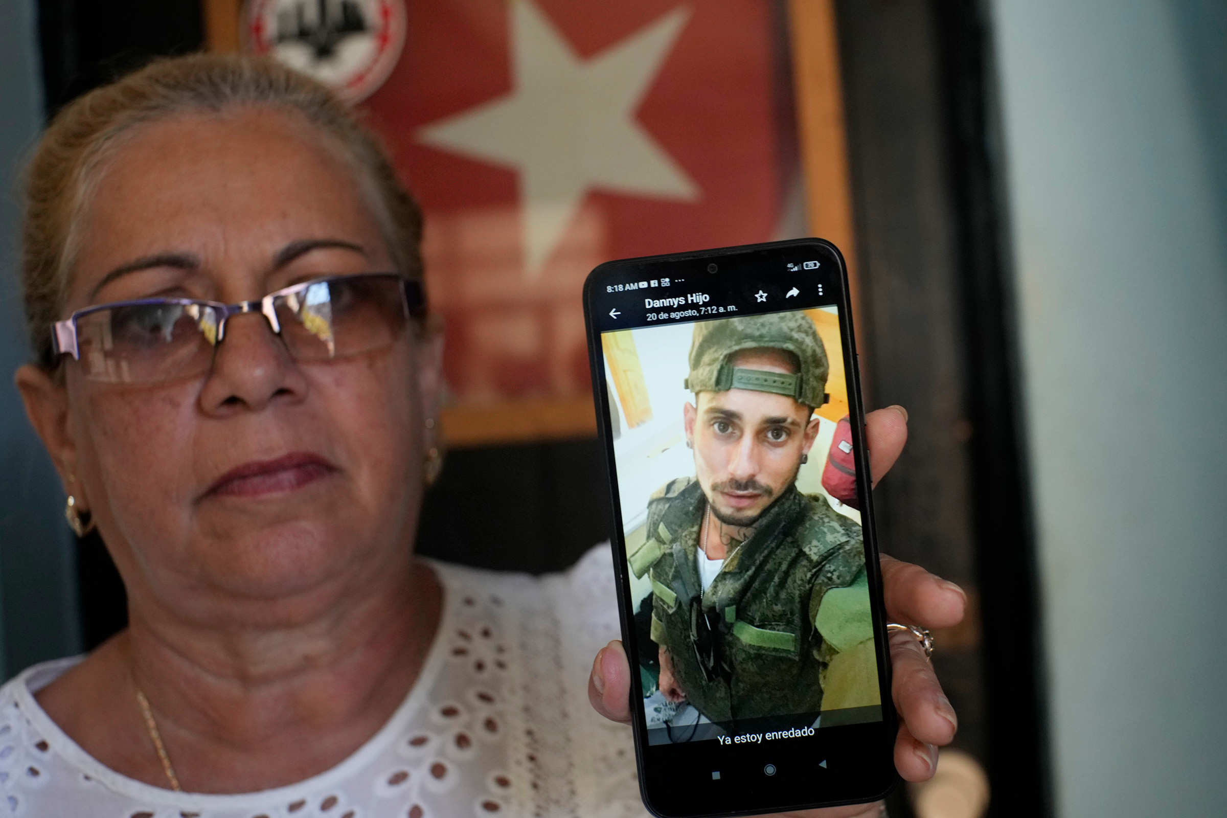Marilin Vinent holds up a photo of her son Dannys Castillo dressed in military fatigues in an Aug. 22 message from her son that reads in Spanish "I'm already entangled" during an interview at her home in Havana, Cuba, Friday, Sept. 8, 2023. Vinent said that her son and other Cubans traveled at the end of July to Russia after being promised work in a construction job, but that he was one of the Cubans recruited to fight for Russia in Ukraine.  (Ramon Espinosa—AP)