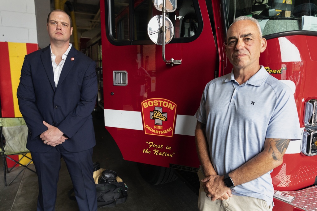 Boston firefighter Daniel Ranahan, left, and retired Brockton deputy fire chief Joe Marchetti pose at the Engine 28 fire station, on July 14, 2023, in the Jamaica Plain neighborhood of Boston. Both Ranahan and Marchetti are cancer survivors.  (Michael Dwyer—AP Photo)