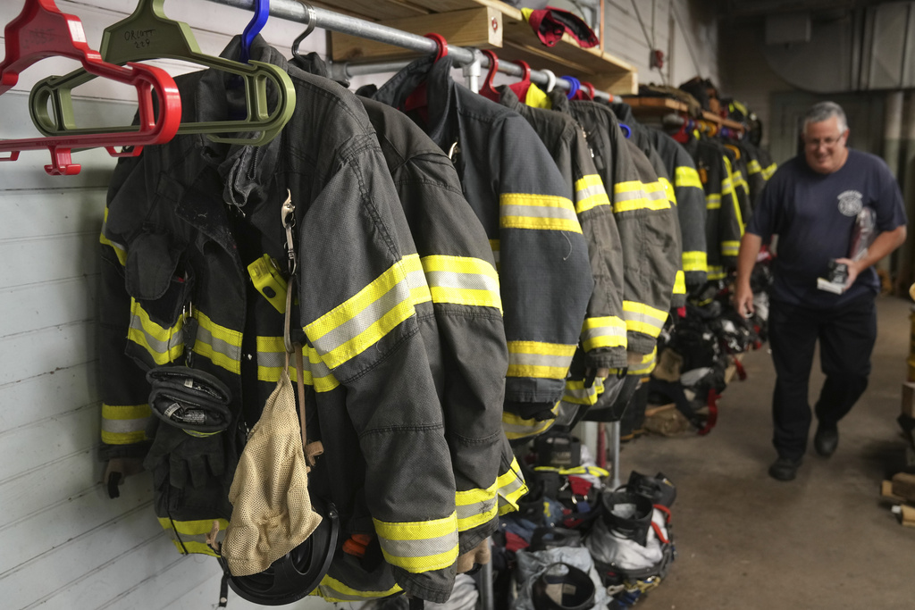 A Brockton, Mass., firefighter walks past protective gear at the station on Aug. 3, 2023. (Steven Senne—AP Photo)