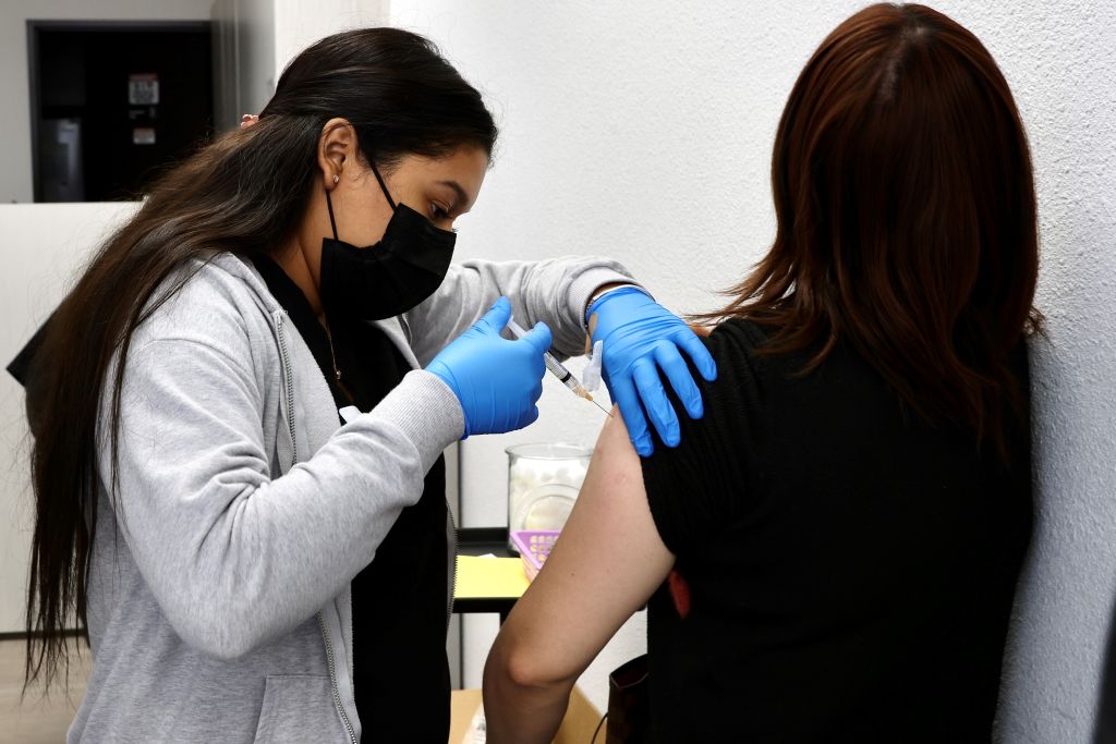 A health care worker administers a flu shot