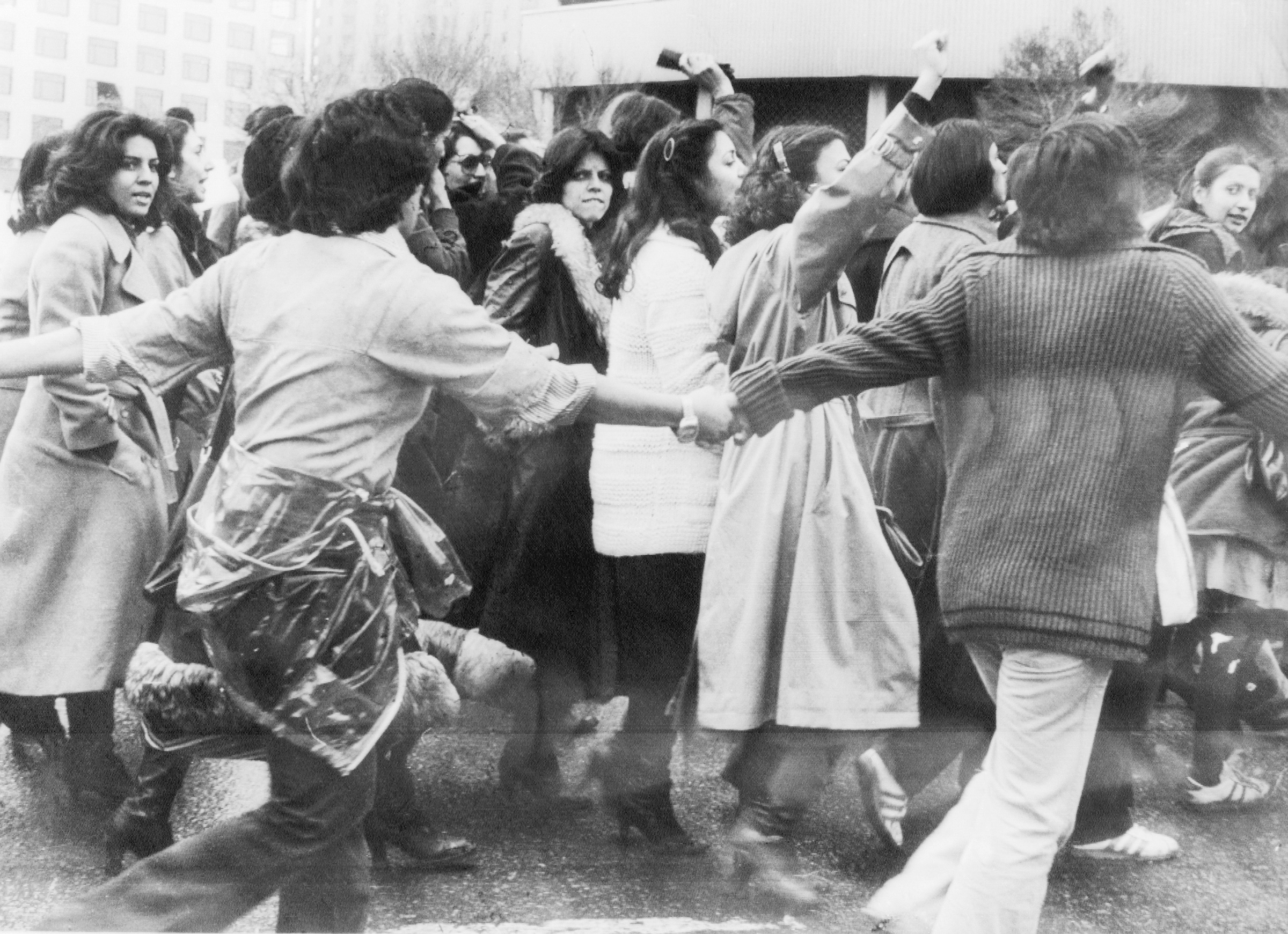 Women protestors, surrounded by men as a form of protection, march against the veil in Tehran, on March 10, 1979.